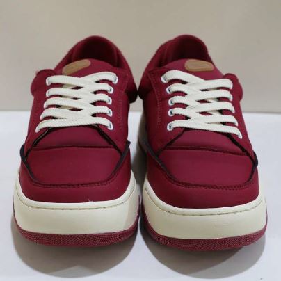 Ein Paar rote Sneakers mit weißen Schnürsenkeln und weißen Sohlen auf einem neutralen Hintergrund.