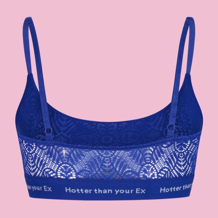 Blaues Spitzen-Bralette mit Aufschrift "Hotter than your Ex" auf einem rosa Hintergrund.