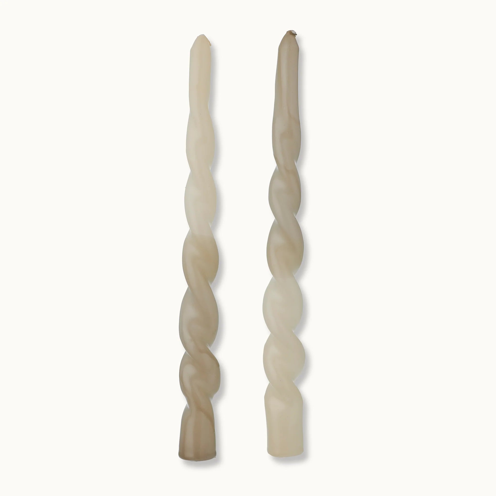 Zwei spiralförmige Drehkerzen in natürlichen Beigetönen stehen aufrecht nebeneinander vor einem schlichten weißen Hintergrund.