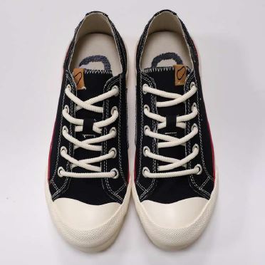 Schwarze und rote Turnschuhe mit weißen Schnürsenkeln und weißer Spitze auf weißem Hintergrund.