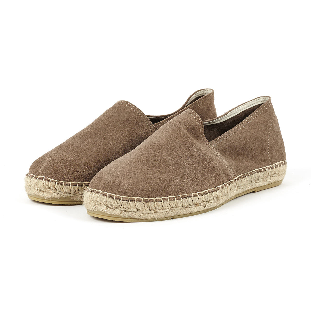 Braune Espadrilles mit geflochtener Sohle aus Bast, seitlich von vorne fotografiert.