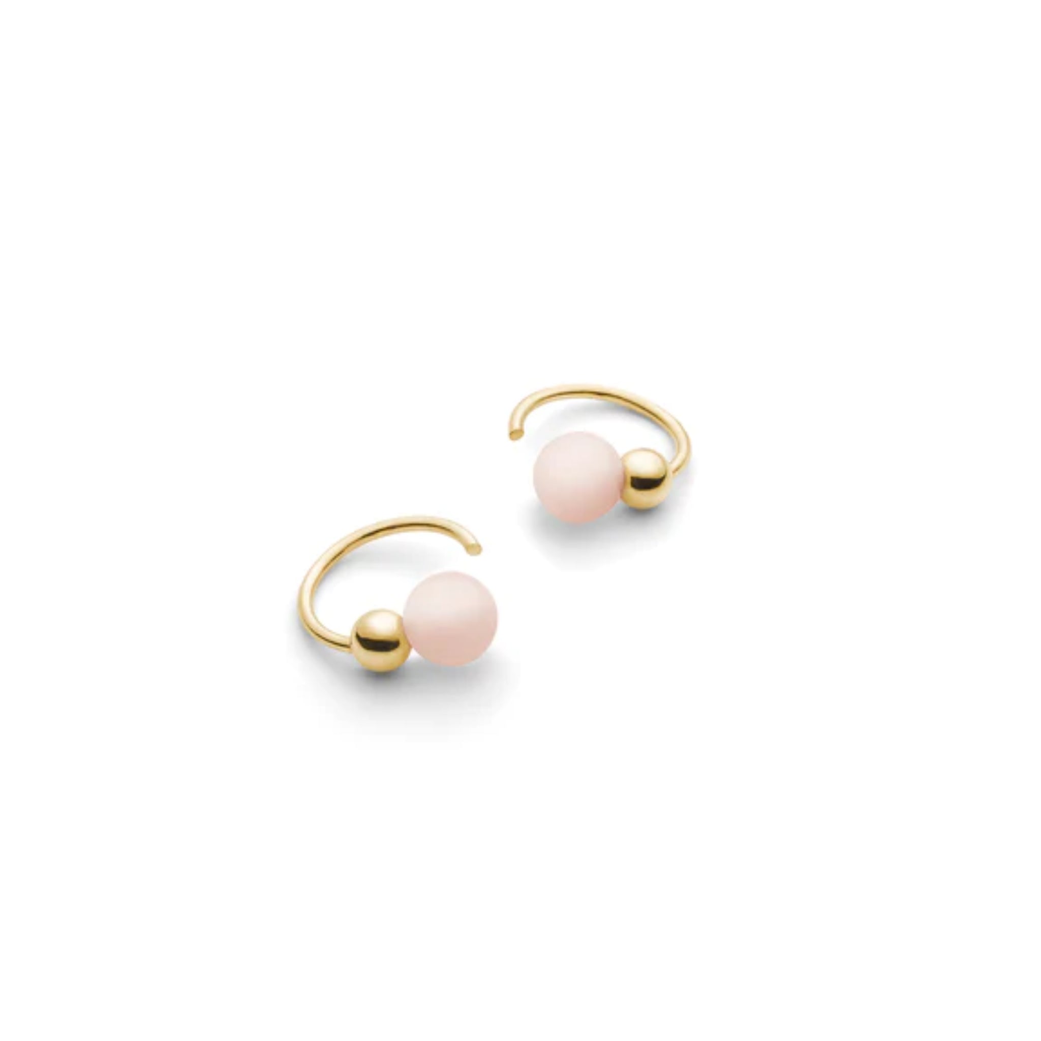 Goldene Ringe mit einer rosafarbenen Perle und einer kleinen goldenen Kugel auf weißem Hintergrund.