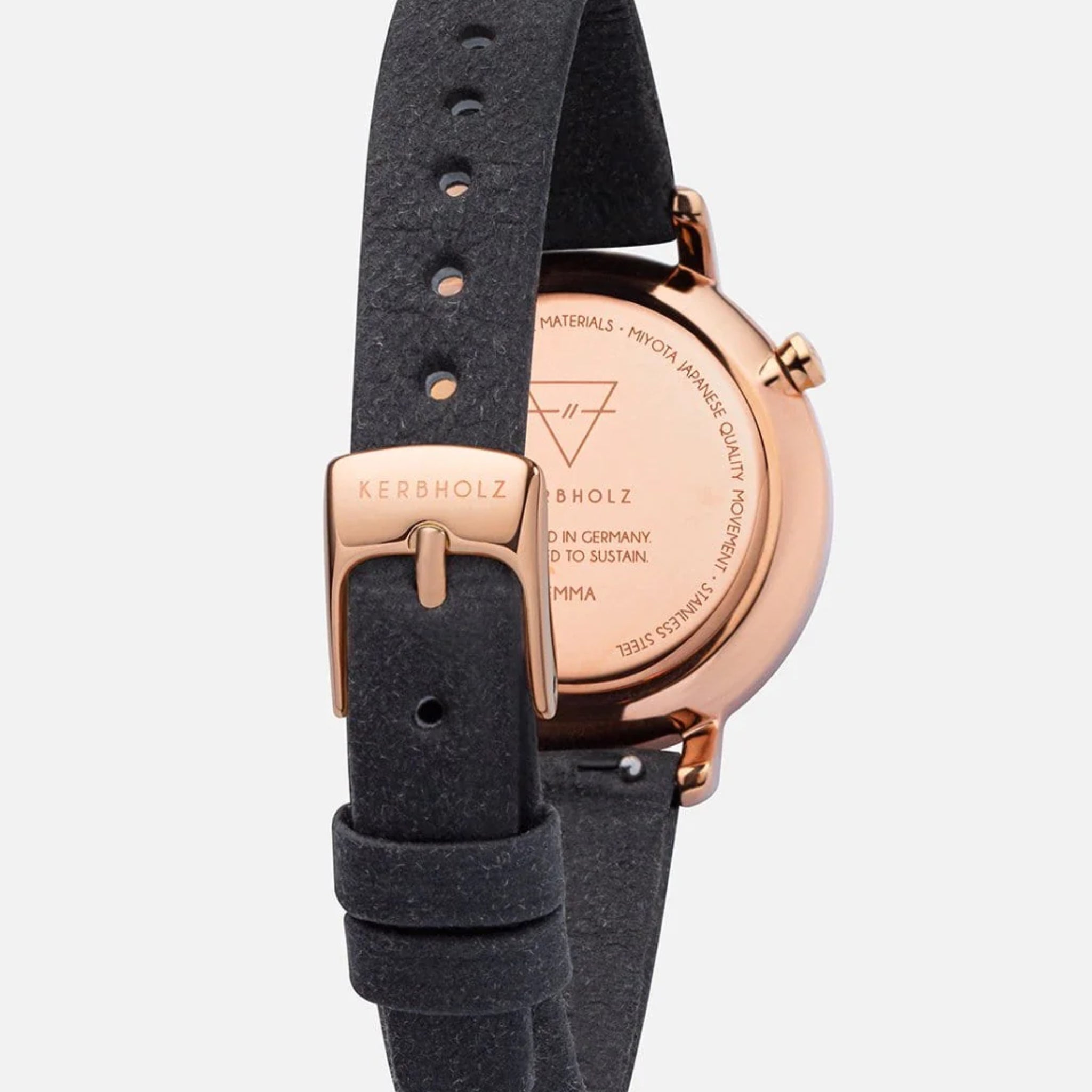 Rückansicht einer Armbanduhr mit schwarzem Lederarmband und einem Gehäuse aus roségoldfarbenem Metall.