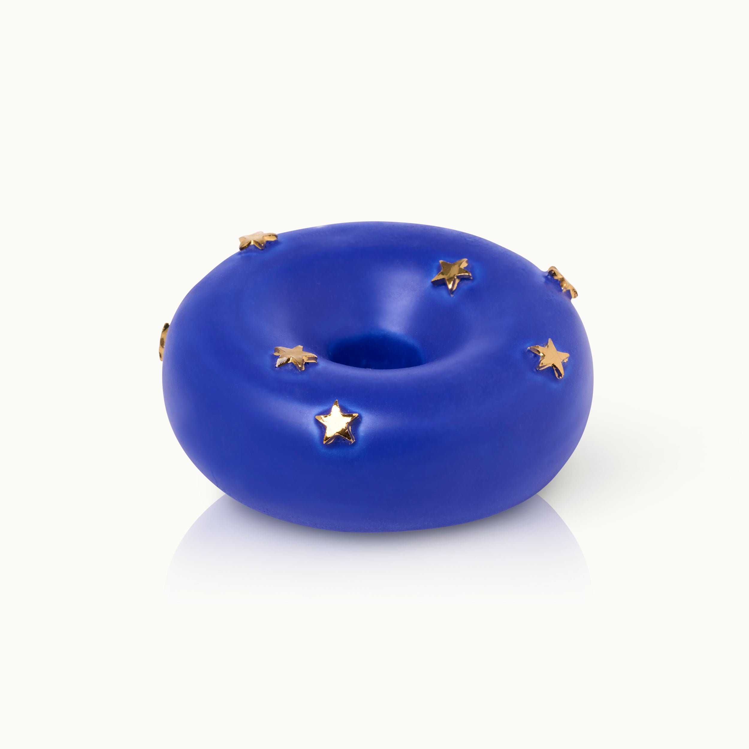 Blauer Donut-förmiger Gegenstand mit goldenen Sternen auf weißem Hintergrund.