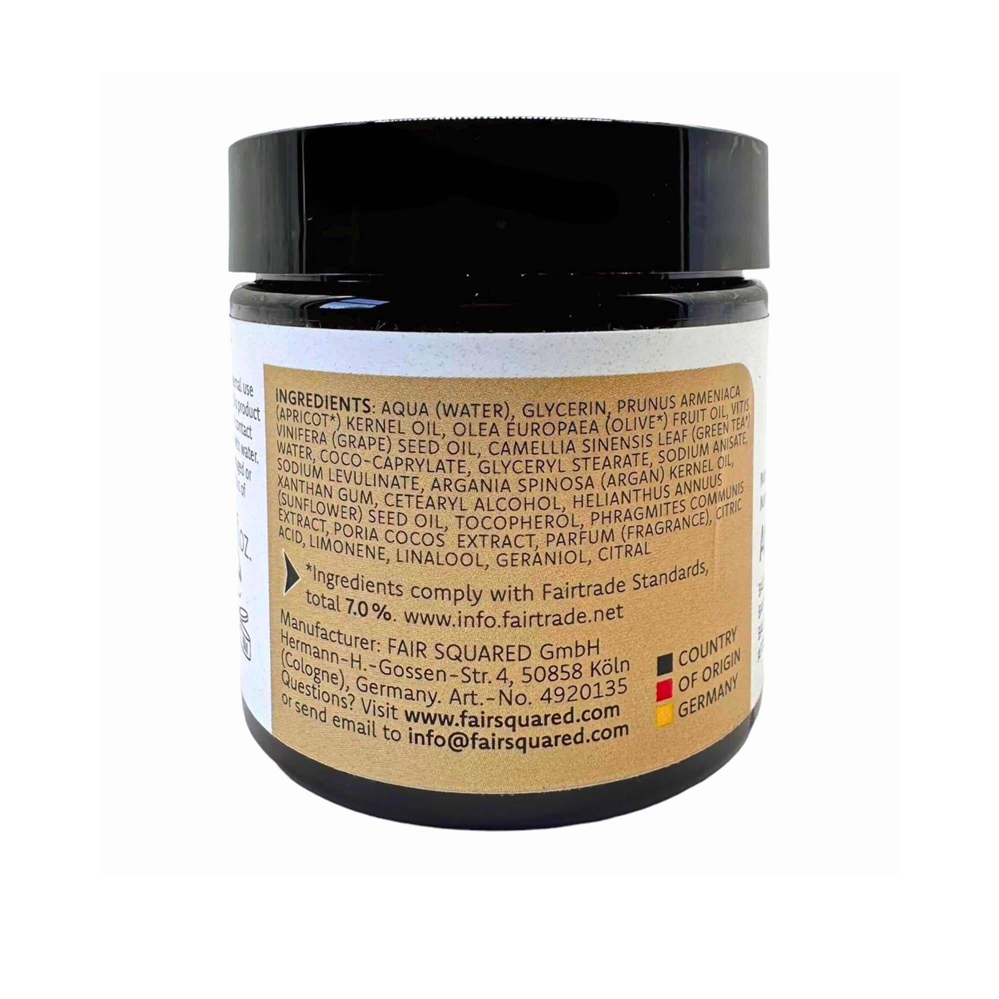 Ein schwarzes Glas mit einem hellbraunen Etikett, das Zutaten und Produktinformationen in englischer Sprache enthält, einschließlich Angaben zur Fairtrade-Konformität, zum Hersteller und zu Kontaktinformationen. Die Dose ist vor einem weißen Hintergrund fotografiert.