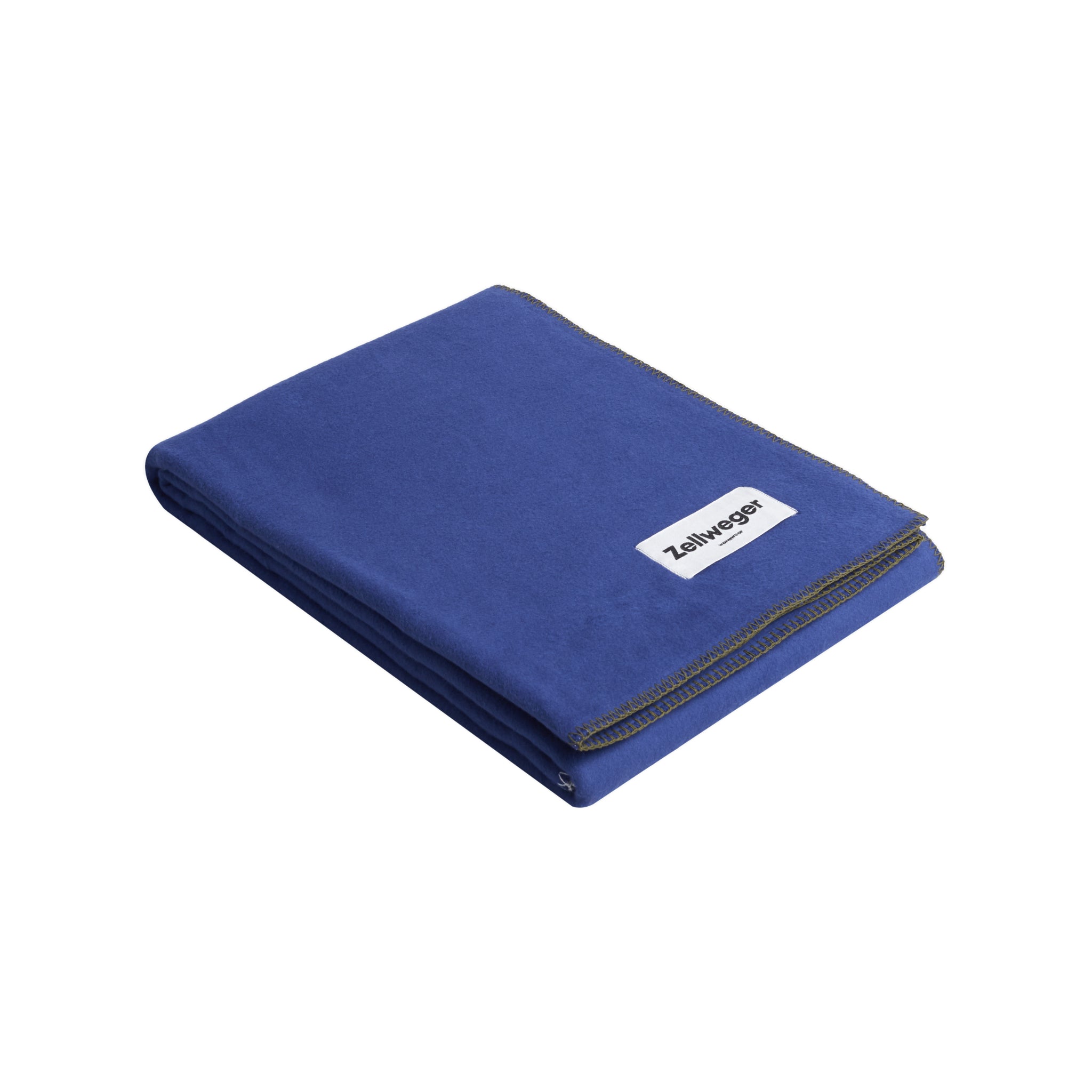 Gefaltete dunkelblaue Decke mit aufgenähtem Etikett auf einer weißen Fläche.