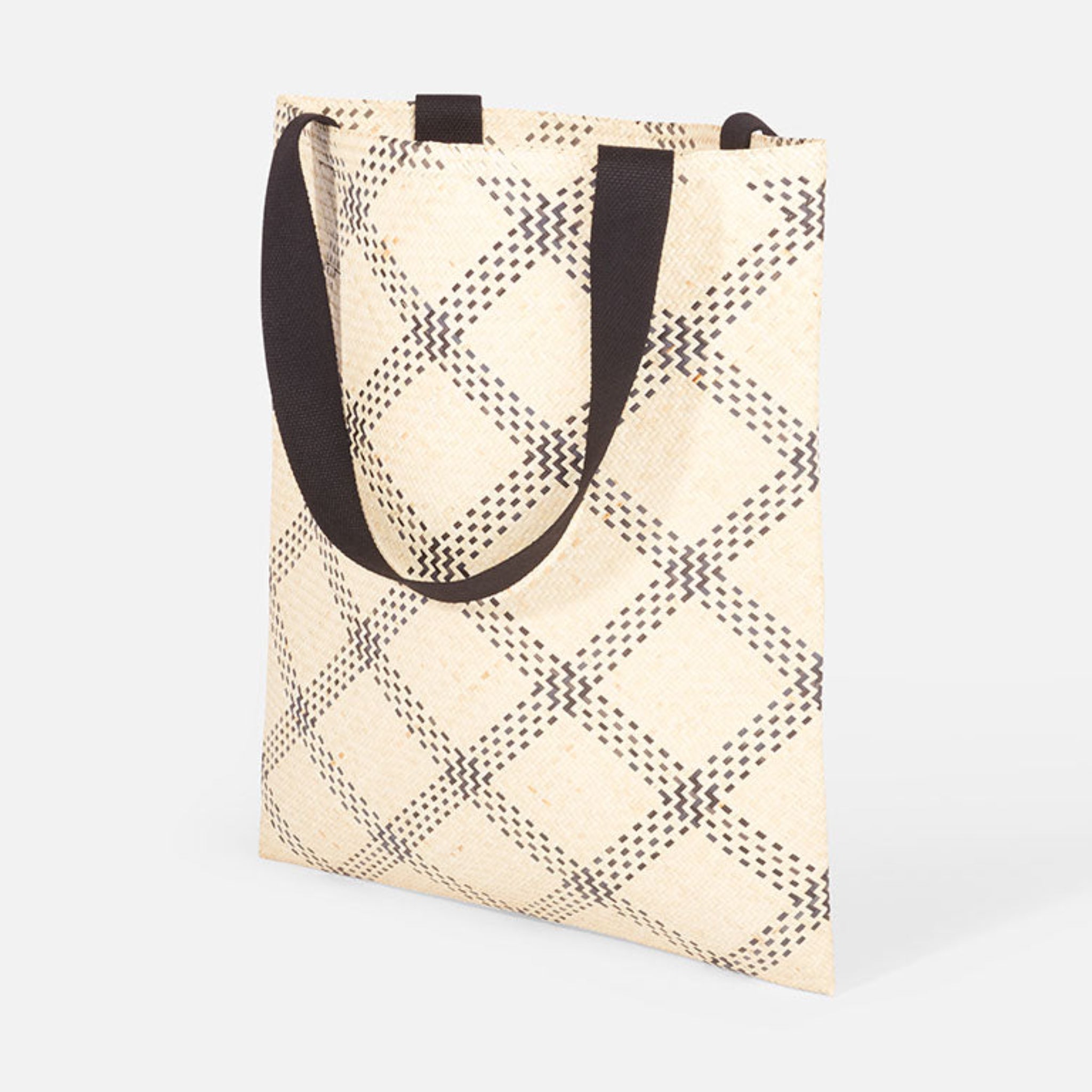 Stofftasche mit geometrischem Muster und schwarzen Henkeln auf weißem Hintergrund.