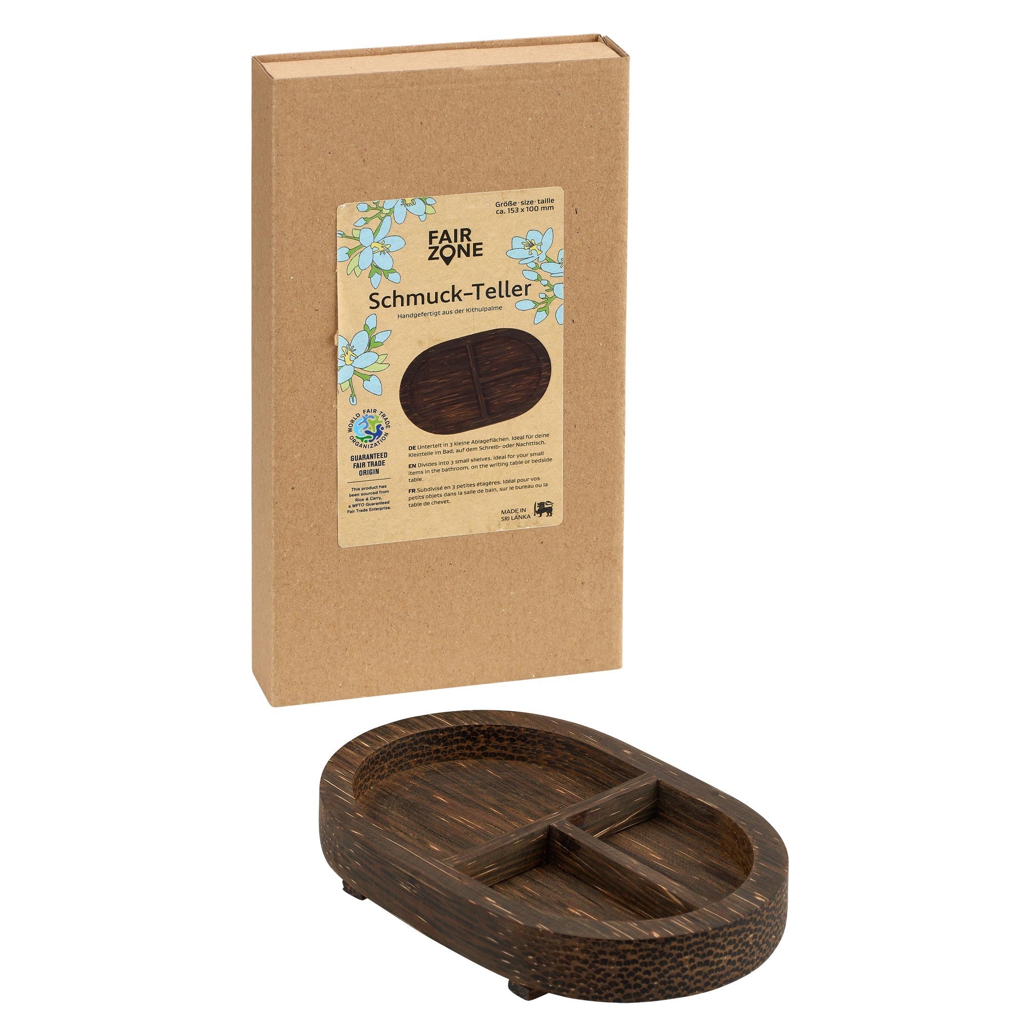 Ein kleines, ovales, geteiltes Schmuck-Tablett aus dunklem Holz wird vor seiner braunen Kartonverpackung mit der Aufschrift Schmuck-Teller mit Blumenmuster und FAIR ZONE-Branding gezeigt.