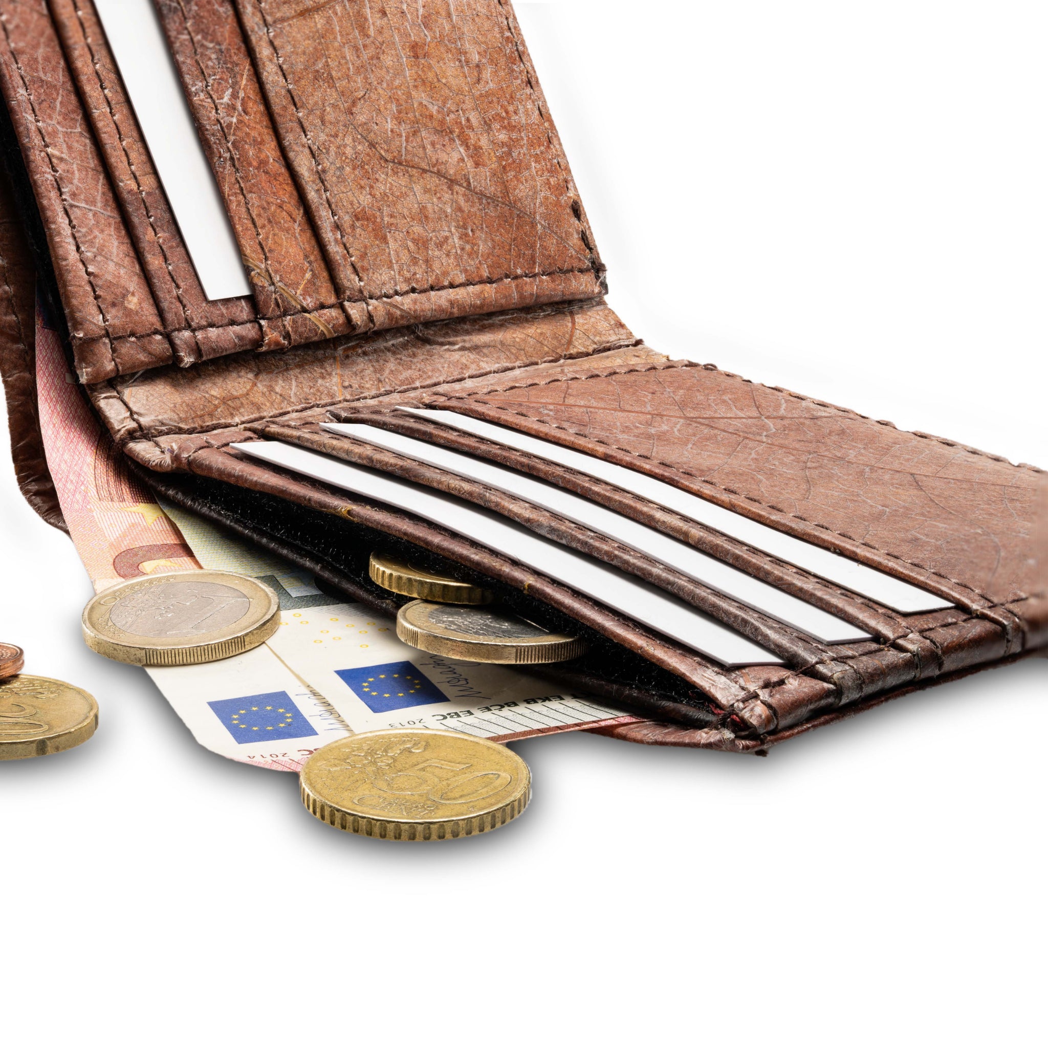 Braune Geldbörse mit Euro-Scheinen und -Münzen, die teilweise herausragen, auf weißem Hintergrund.