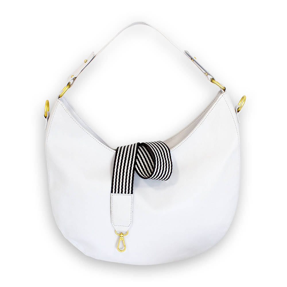 Weiße Handtasche mit einem gestreiften, schwarz-weißen Band und goldenen Details, vor weißem Hintergrund.