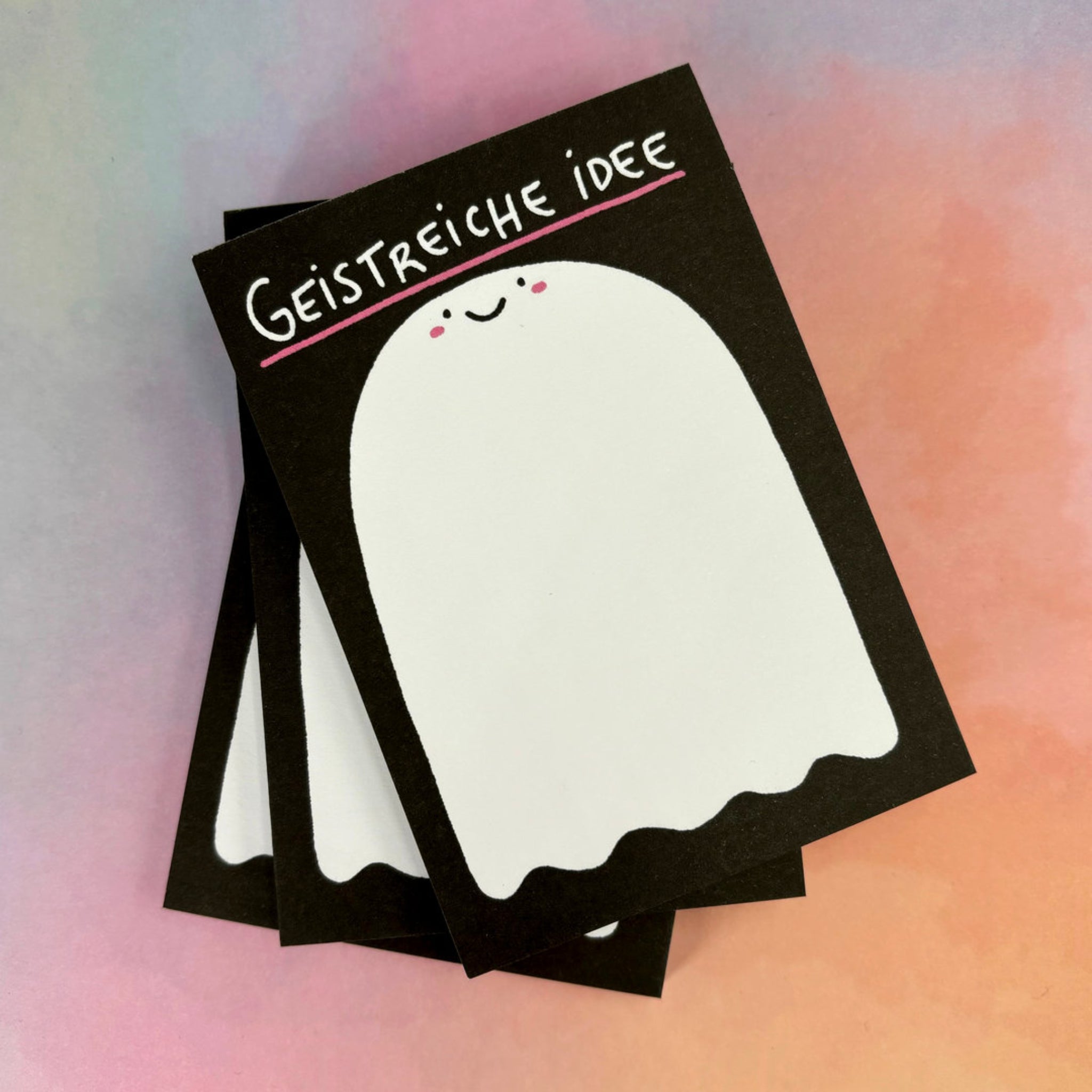 Karten mit einem niedlichen Geist und der Aufschrift "Geistreiche Idee" vor einem bunten, weichen Hintergrund.