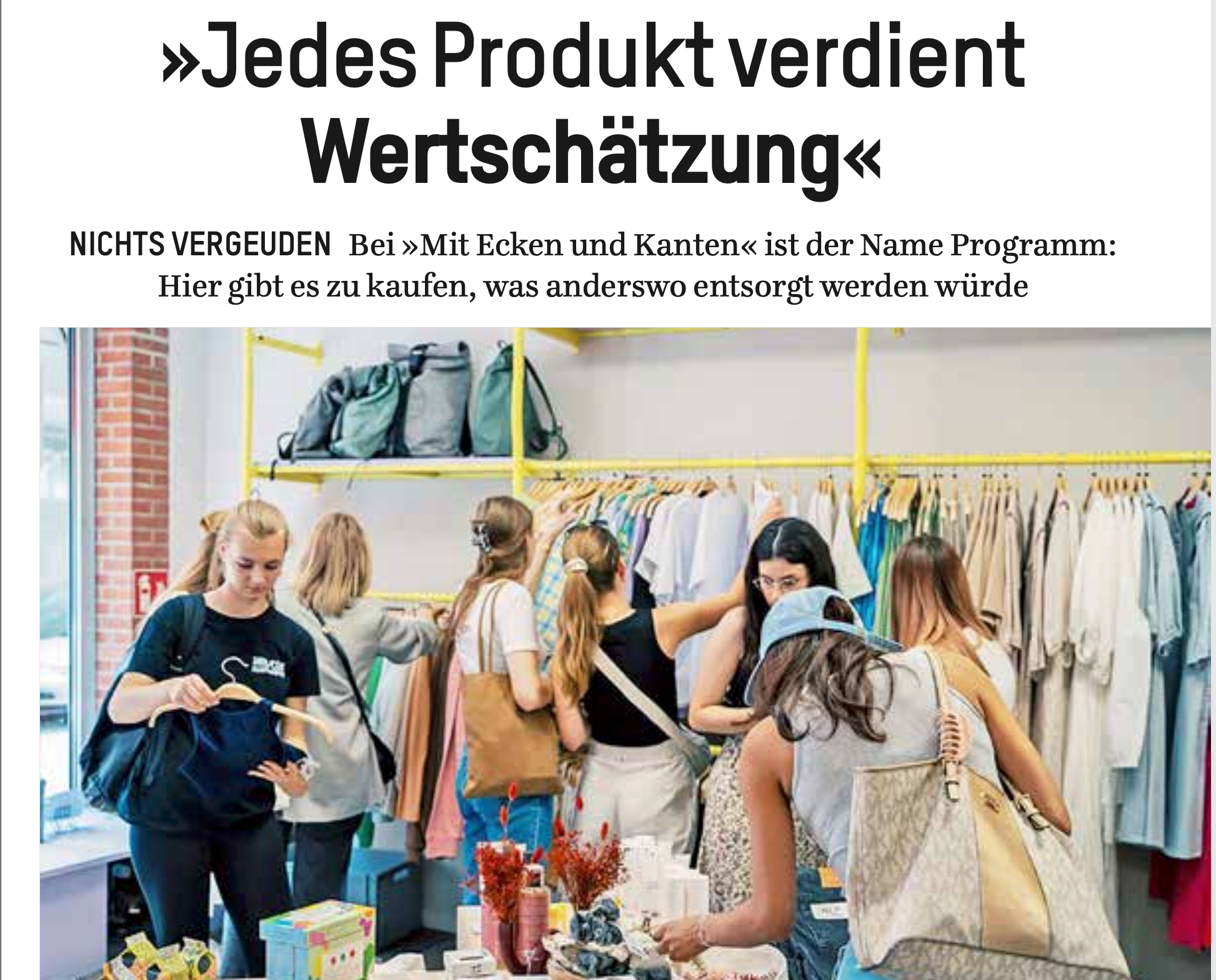 Mehrere Personen stöbern in einem Second-Hand-Laden mit Regalen voller Kleidung und Accessoires.