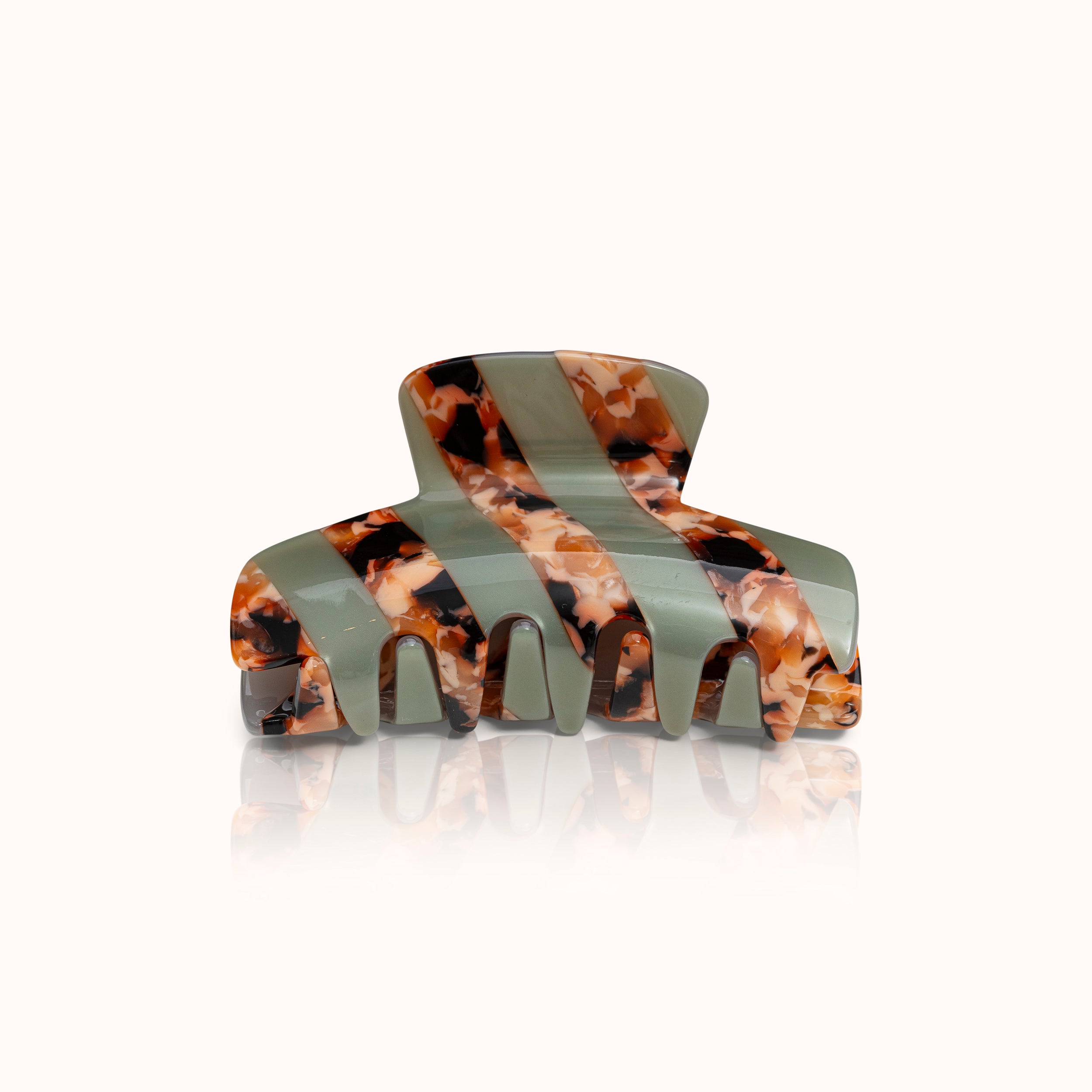Haarspange mit abwechselnden grünen und marmorierten orange-braunen Mustern auf hellem Hintergrund.