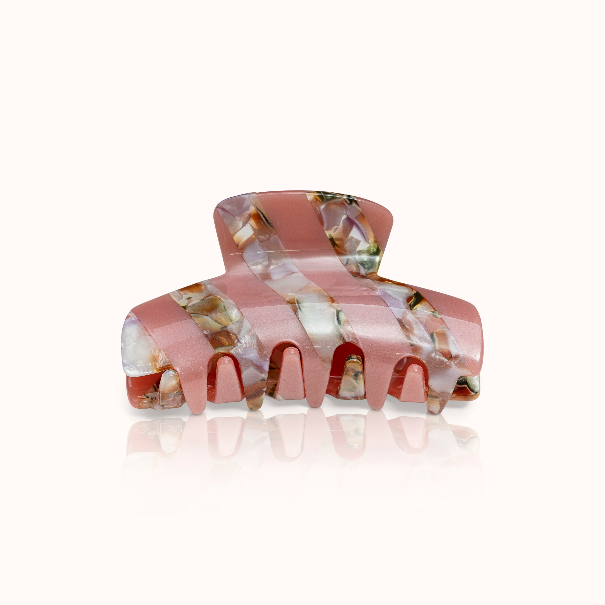 Rosa Haarklammer mit marmoriertem Muster in Braun- und Beigetönen auf hellem Hintergrund.