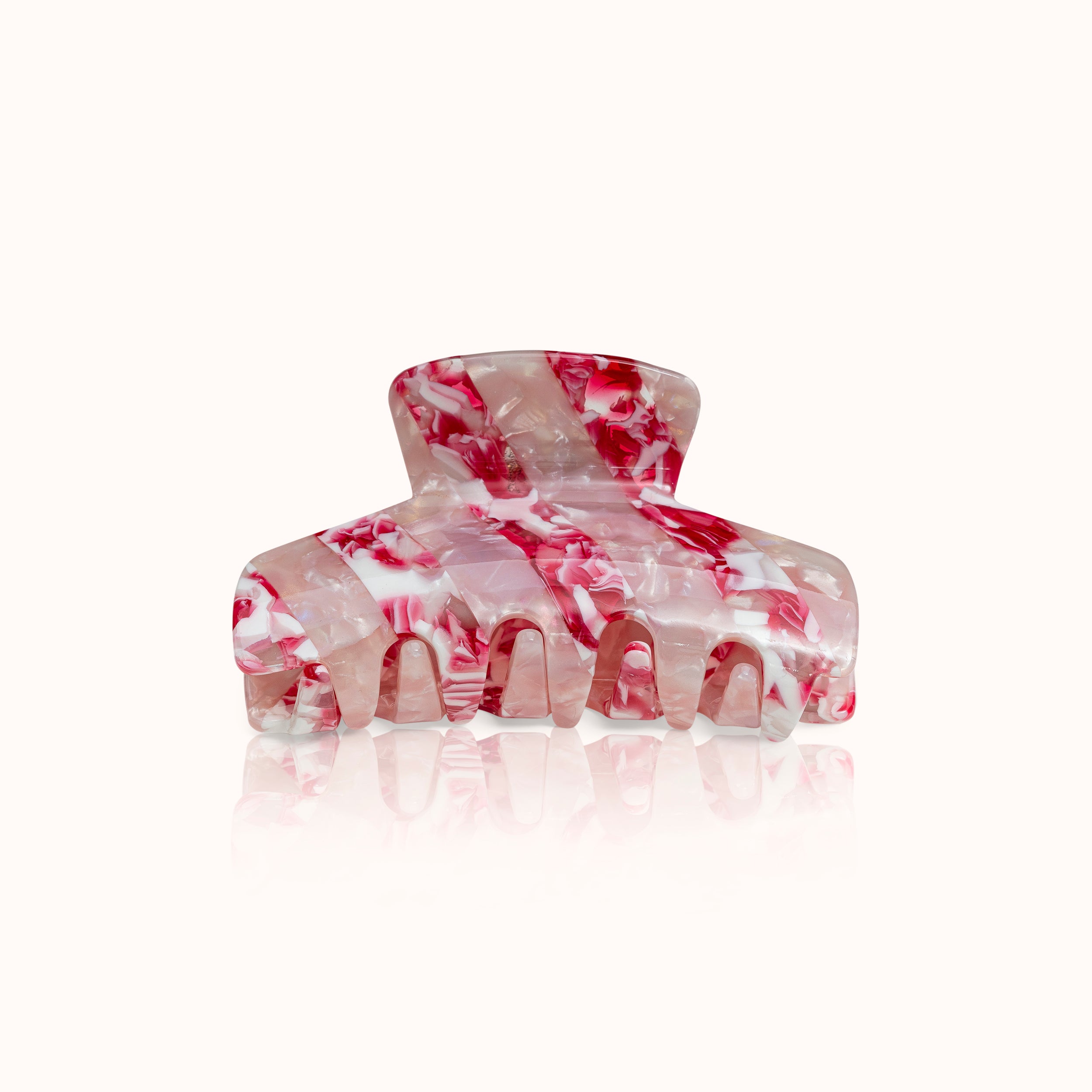 Rosafarben-weiß gemusterte Haarklammer auf hellem Hintergrund.