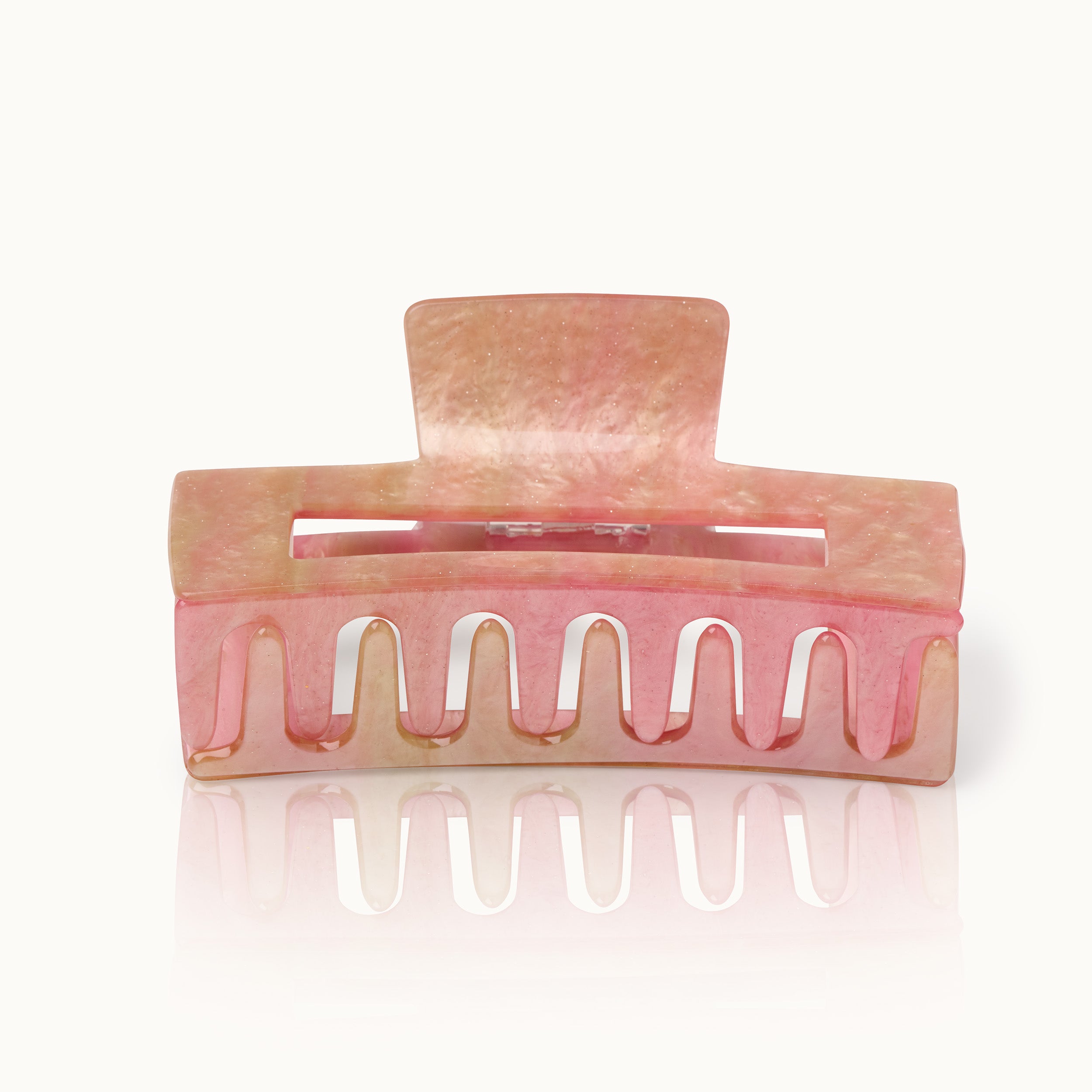 Rosafarbene Haarklammer aus Kunststoff mit glänzendem Finish und leichtem Farbverlauf auf einem weißen Hintergrund.