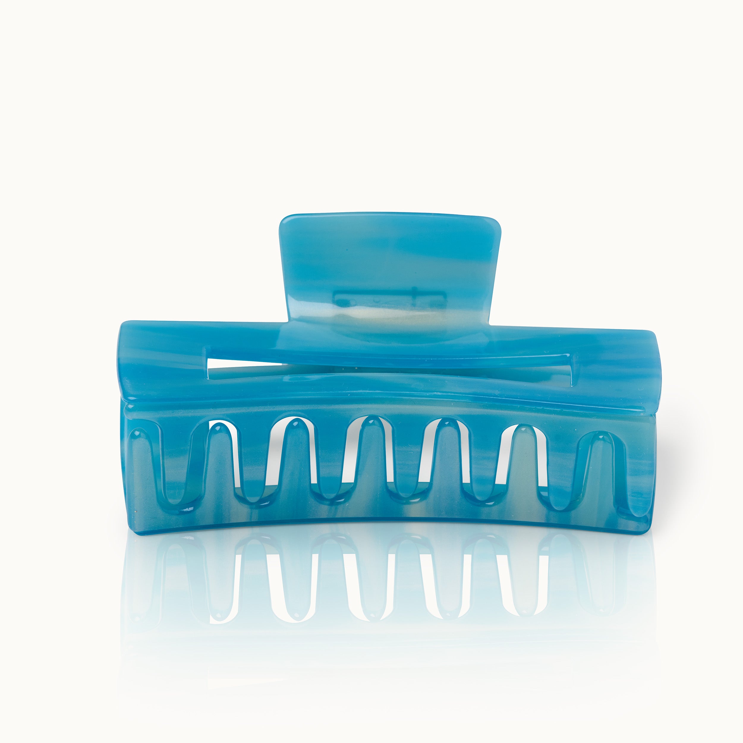 Blauer Haarklipp mit wellenförmigen Zähnen auf weißem Hintergrund.