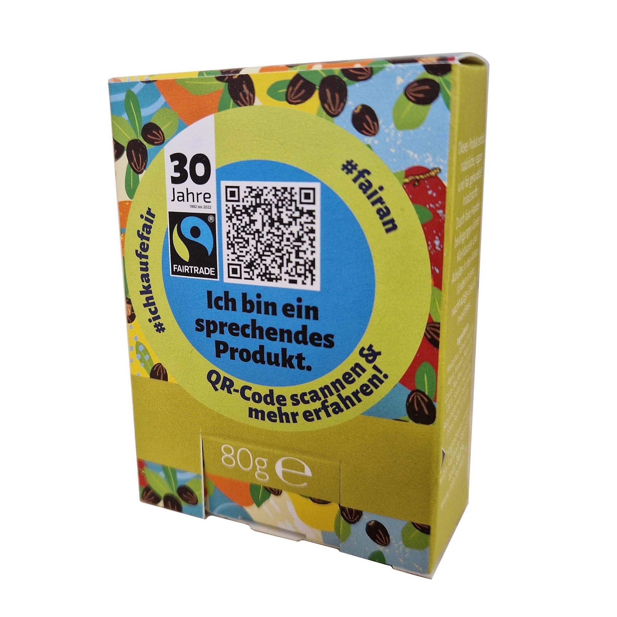 Eine farbenfrohe Schachtel mit Abbildungen von Kaffeebohnen, einem blauen Fairtrade-Etikett, einem QR-Code und dem deutschen Text "Ich bin ein sprechendes Produkt". Die Schachtel hat einen gelb-grünen Kreis und die Angabe 80 g.