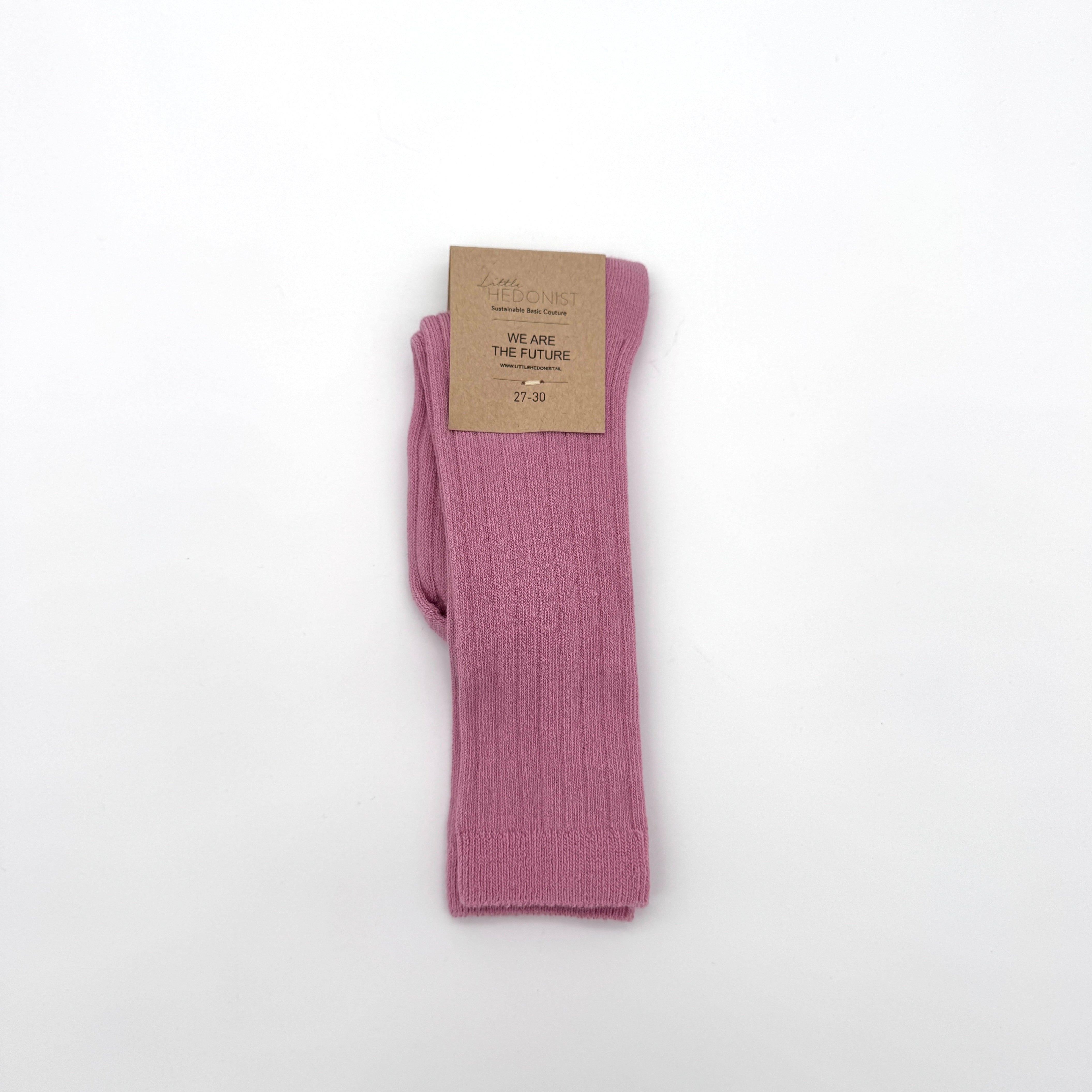 Ein Paar gefaltete rosafarbene gerippte Socken mit einem braunen Kartonetikett mit der Aufschrift WE ARE THE FUTURE auf einem schlichten weißen Hintergrund.
