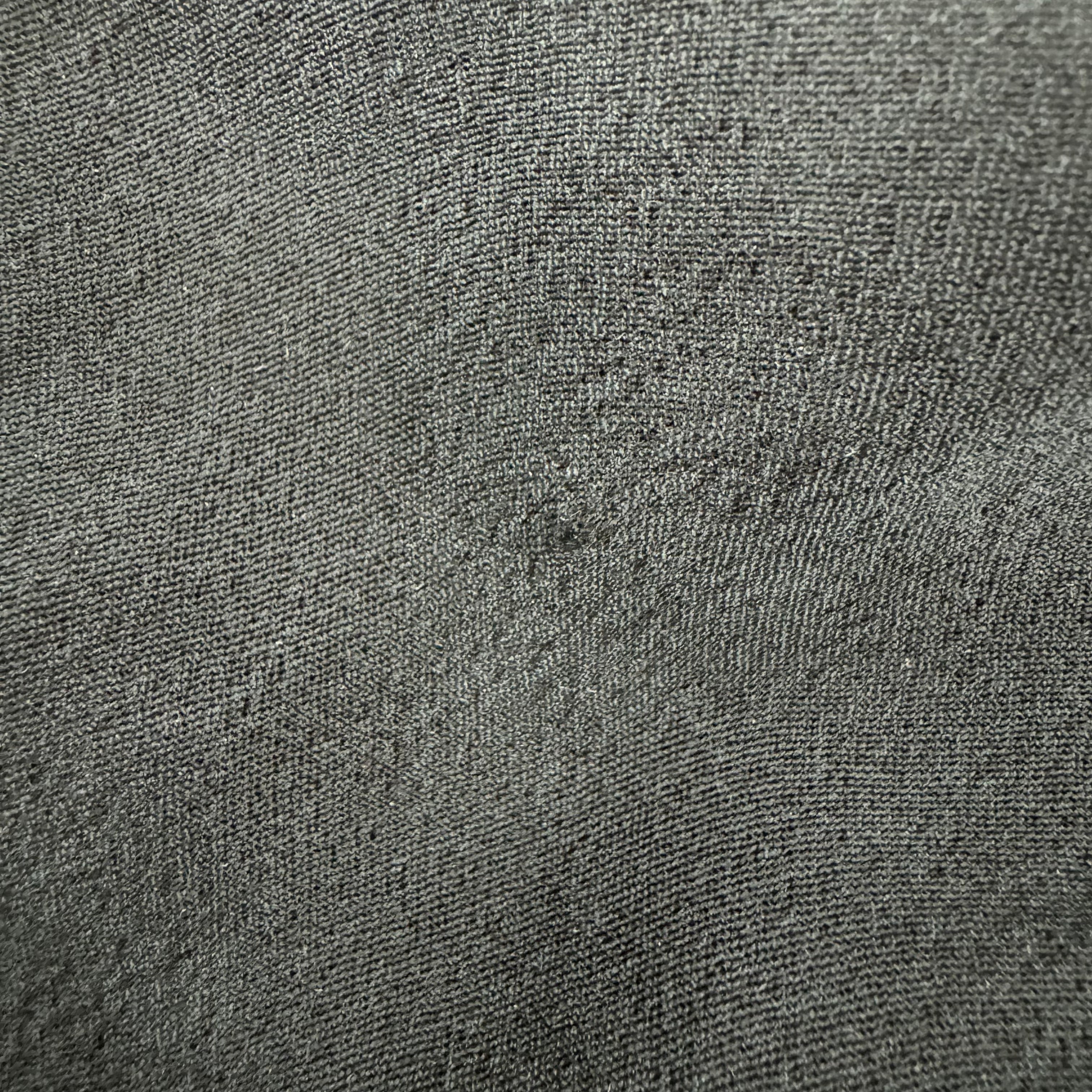Grau texturierte Stoffoberfläche mit sichtbarer Webstruktur.