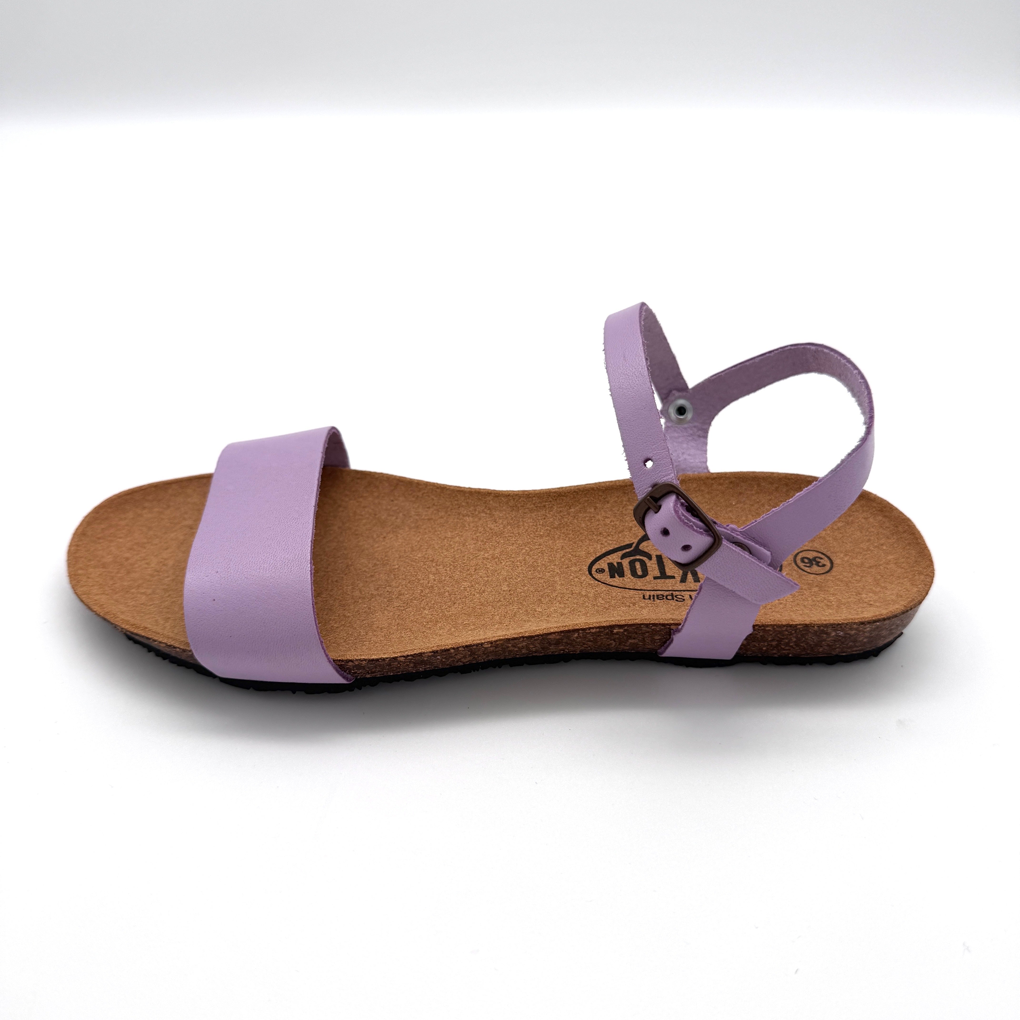 Lila Sandale mit breitem vorderen Riemen und verstellbarem Knöchelriemen auf einer braunen Korksohle.