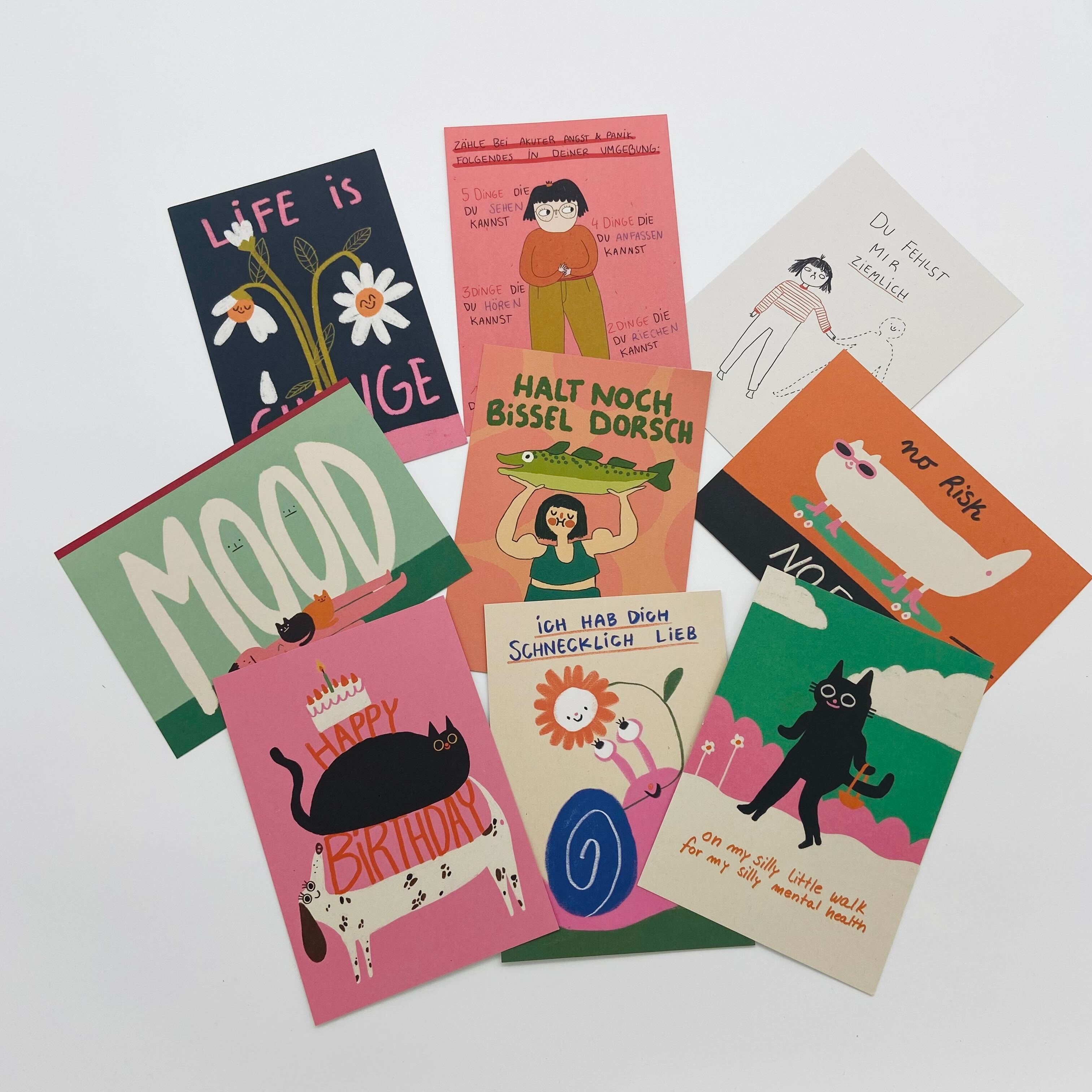 Bunte Postkarten mit humorvollen und positiven Sprüchen sowie Illustrationen von Tieren und Menschen.