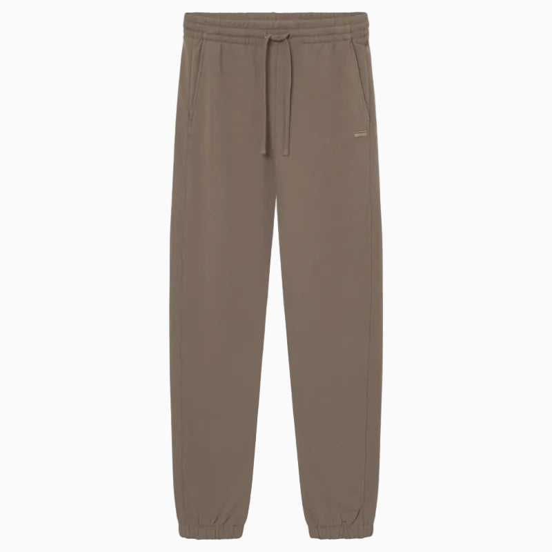 Taupefarbene Jogginghose mit elastischem Bund, Kordelzug, Seitentaschen und elastischen Bündchen auf einfarbig weißem Grund.