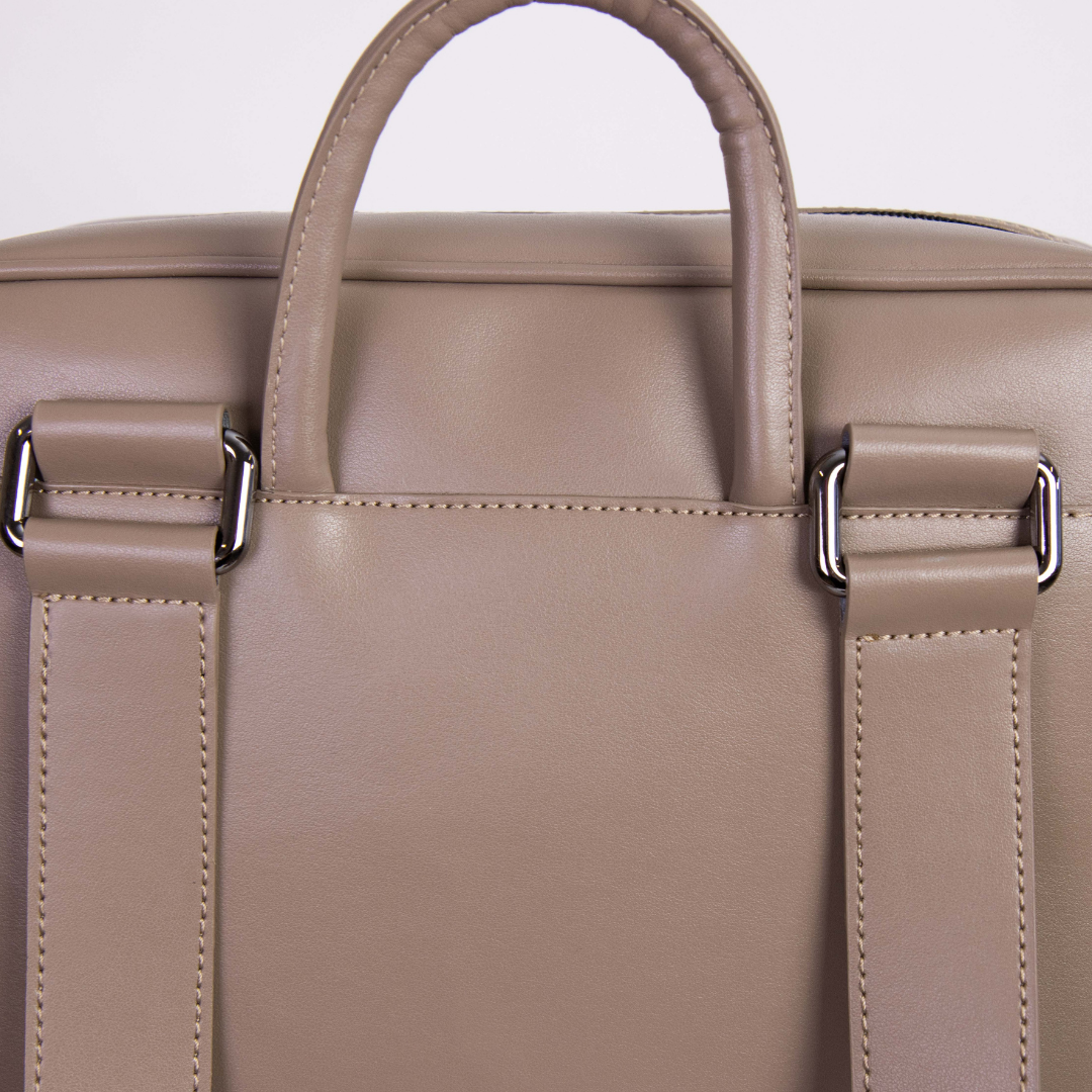 Beige Ledertasche mit Tragegriff und Riemen, Nahaufnahme der Rückseite mit Metallschnallen.