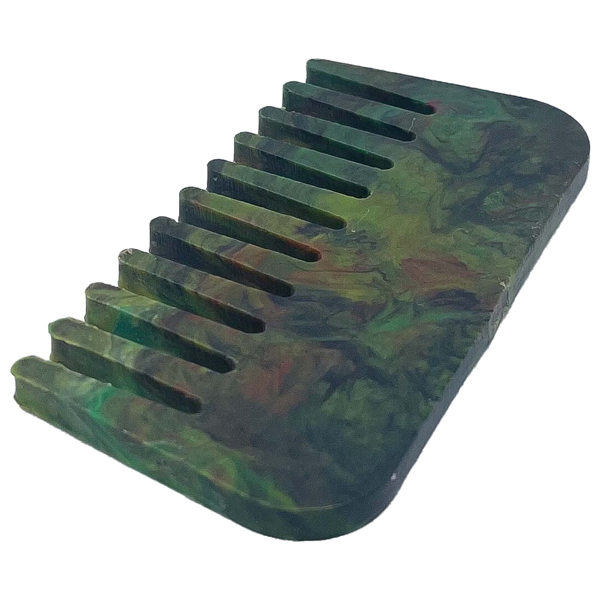 Ein kleiner, rechteckiger Kamm mit breiten Zinken und einem marmorierten Muster in Dunkelgrün, Gelb und einem Hauch von Rot auf weißem Grund.