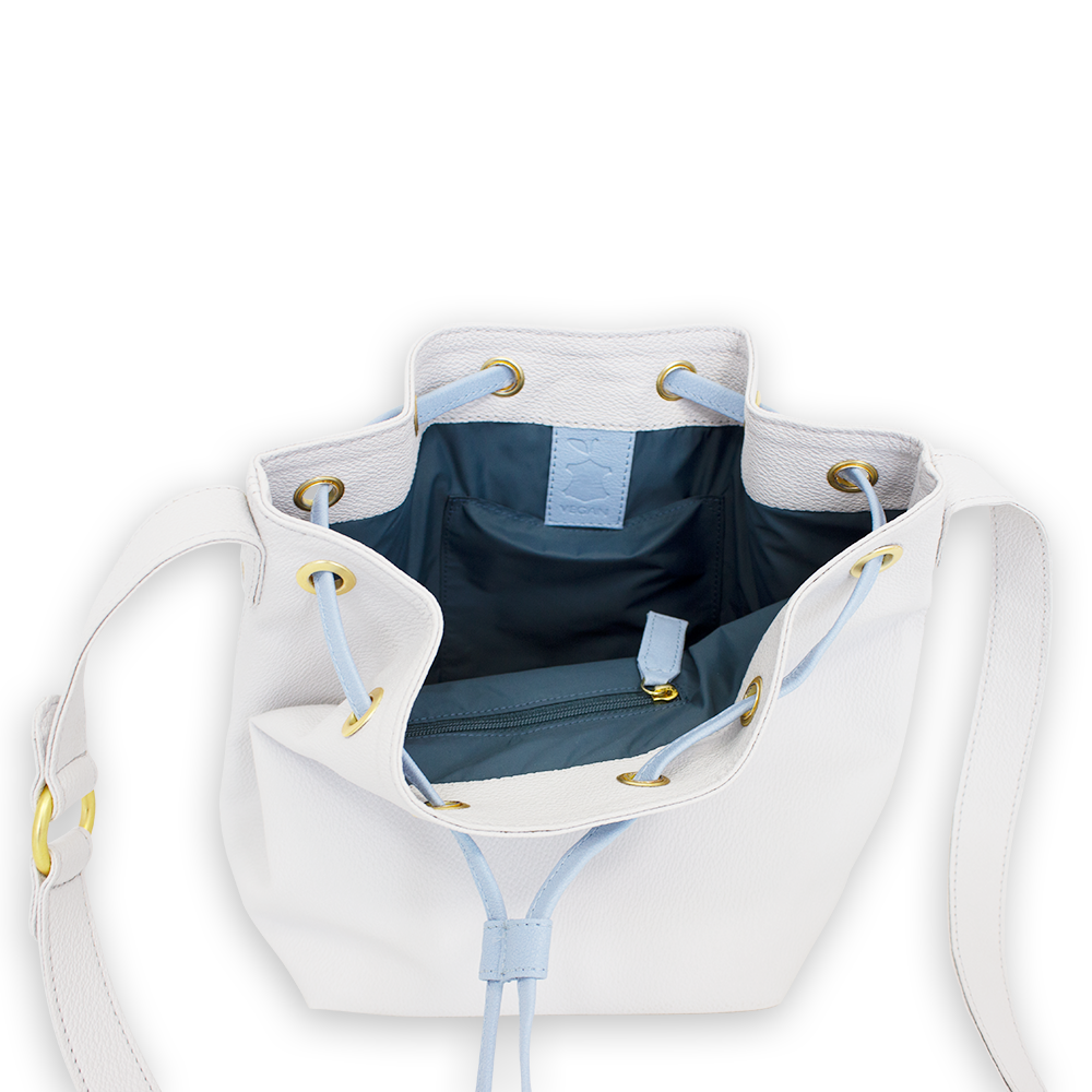 Eine offene weiße Handtasche mit hellblauem Innenfutter und Bändern sowie goldfarbenen Ösen und Reißverschluss.