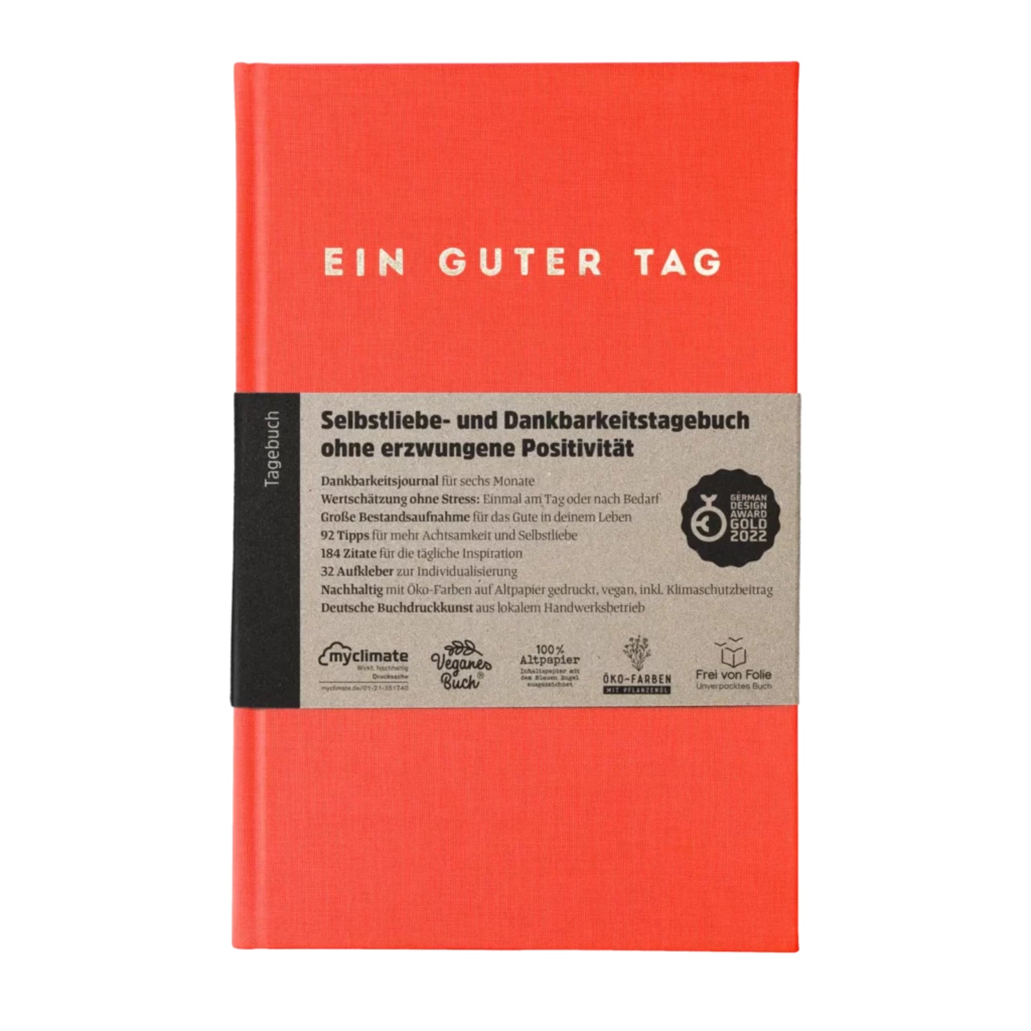 Rotes Tagebuch mit der Aufschrift "EIN GUTER TAG" und Informationen über das Dankbarkeitstagebuch auf einer Banderole.