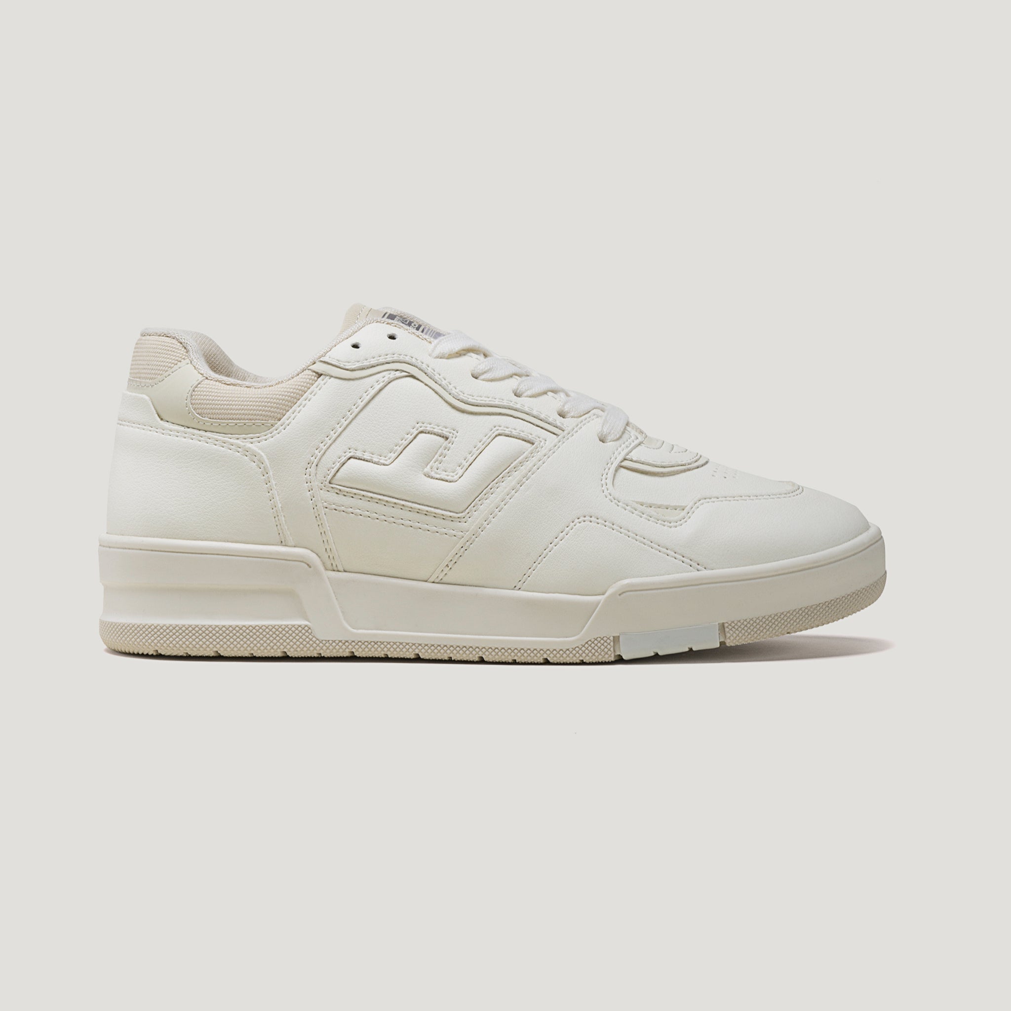 Weiße Sneaker mit einem beigen Muster und einer flachen Sohle auf weißem Hintergrund.