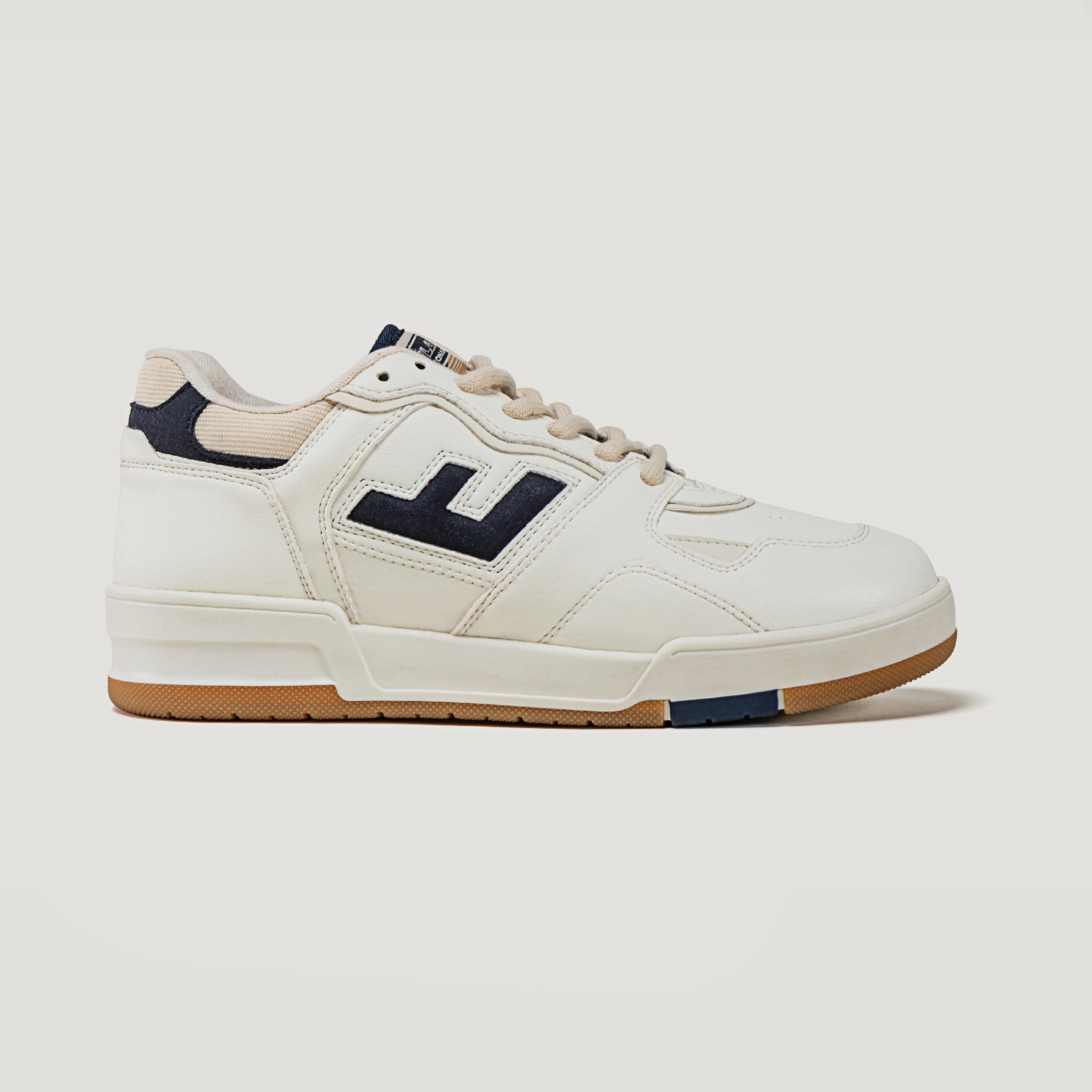 Weißer Sportschuh mit hellbrauner Sohle und dunklem Logo auf der Seite, auf weißem Hintergrund.