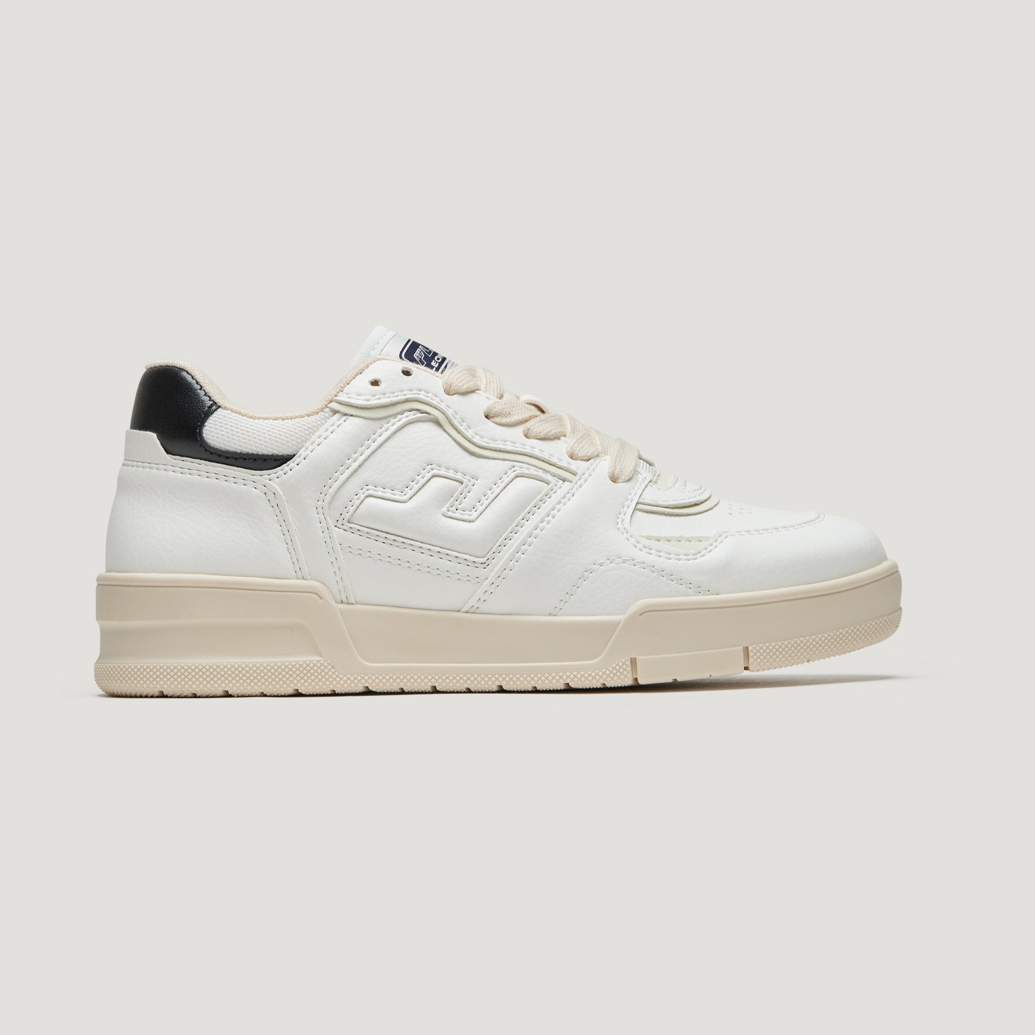 Weißer Sneaker mit beiger Sohle und schwarzem Detail an der Ferse, in Seitenansicht vor neutralem Hintergrund.