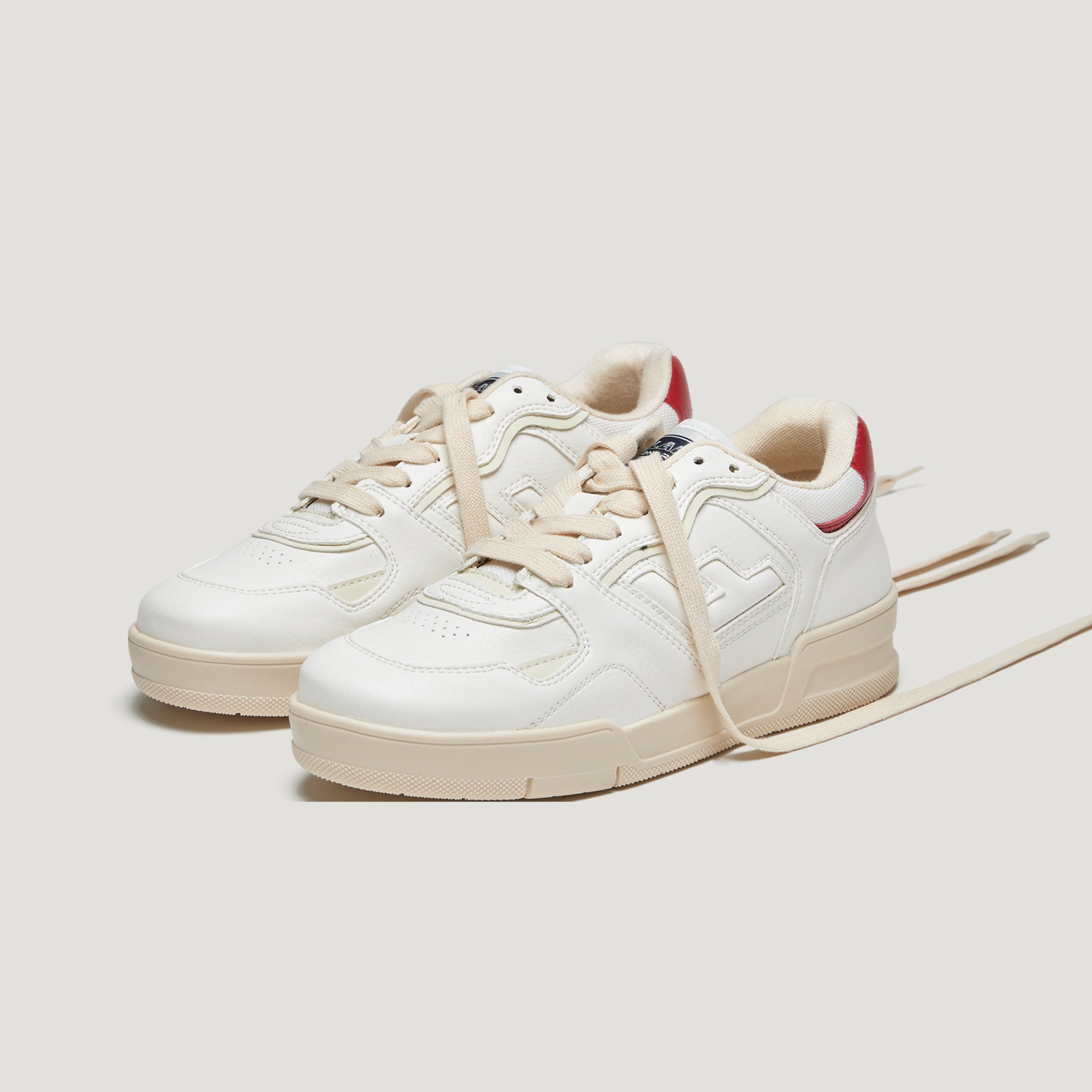 Weiße Sneaker mit beigen Schnürsenkeln und roten Details an der Ferse auf weißem Hintergrund.