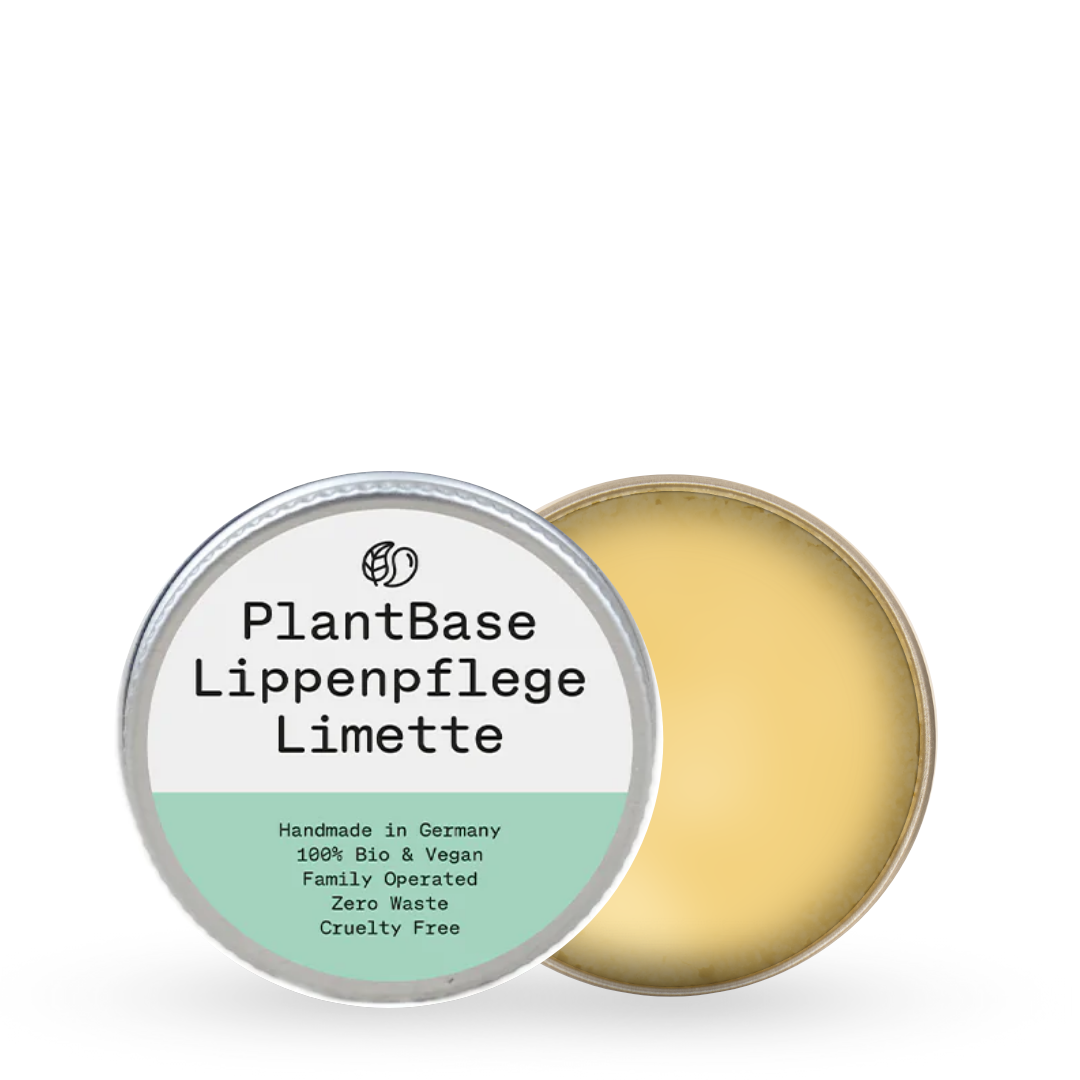 Runde Dose mit der Aufschrift "PlantBase Lippenpflege Limette", daneben offene Dose mit gelblicher Salbe.