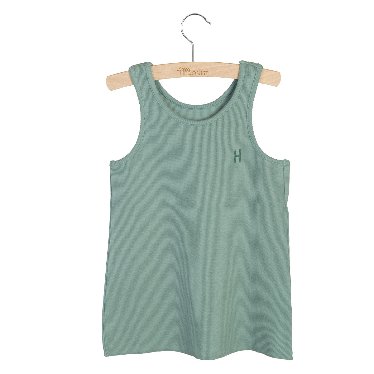 Ein ärmelloses, salbeigrünes, geripptes Tank-Top hängt auf einem Holzbügel vor einem weißen Hintergrund. Das Oberteil hat ein kleines H auf der linken Brust aufgestickt.