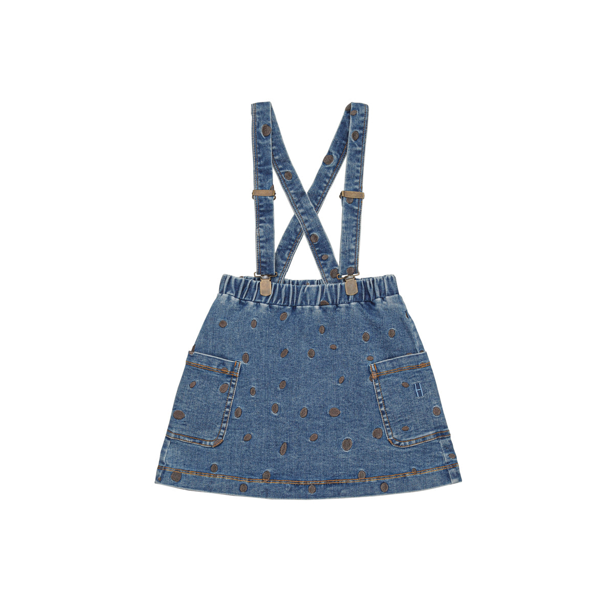 Jeansrock mit zwei Vordertaschen und verstellbaren, sich im Rücken kreuzenden Trägern im Overall-Stil. Der Stoff ist mit einem braunen Tupfenmuster versehen. Der Rock hat einen elastischen Bund.