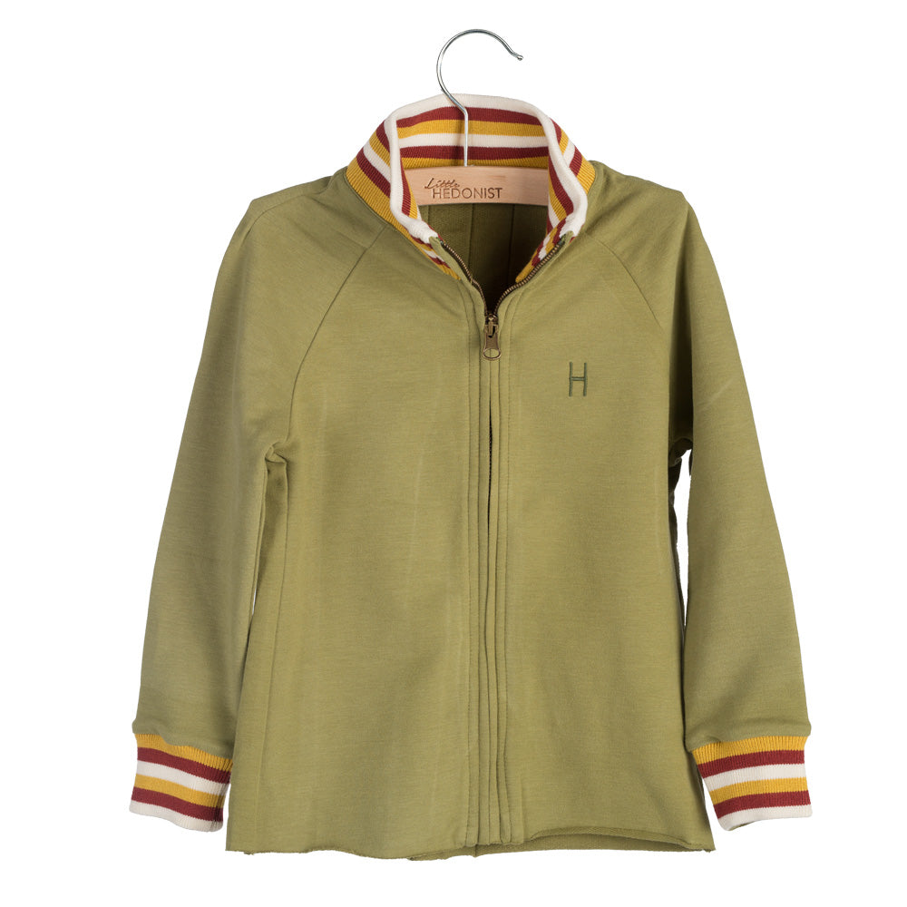Hellolivgrüne Kinder-Zip-up-Jacke mit gestreiften Manschetten und Kragen in Weiß, Gelb und Rot. Auf der linken Brust befindet sich ein kleines H-Emblem und die Jacke wird auf einem Bügel präsentiert.