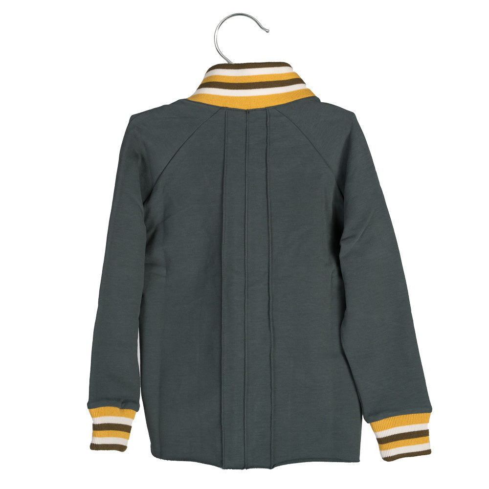 Eine dunkelgrüne, langärmelige Jacke mit gelb-weiß gestreiftem Kragen und Manschetten, die auf einem Bügel ausgestellt ist, von hinten gesehen.