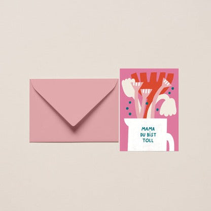 Pinkfarbener Umschlag neben einer Karte mit Blumen und der Aufschrift "Mama du bist toll".