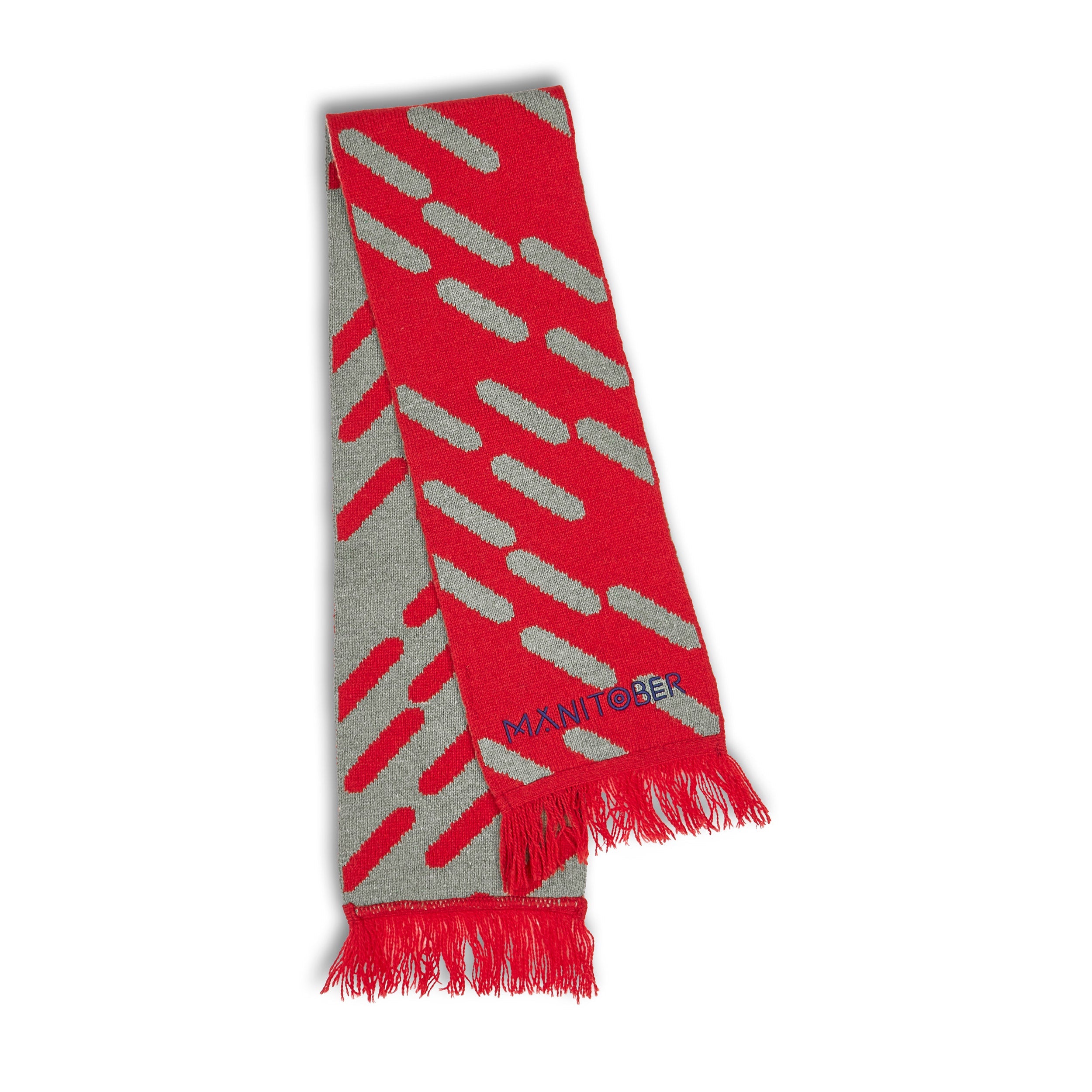 Roter Schal mit grauem Punktmuster und roten Fransen, Aufschrift "MANITOBER" im unteren Bereich.