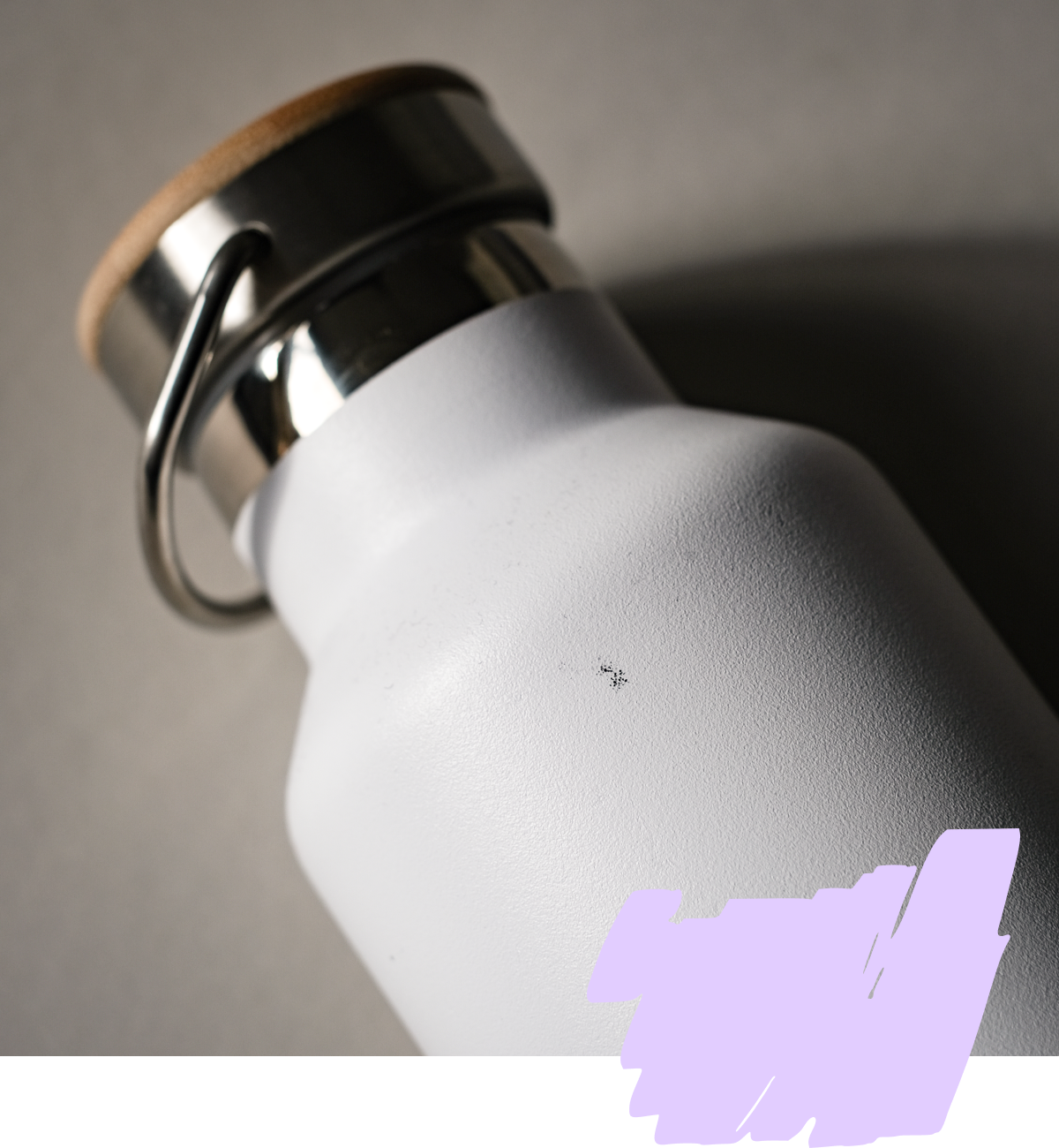 Weiße Wasserflasche mit Metallverschluss und Holzdetails, liegt schräg auf grauem Hintergrund.