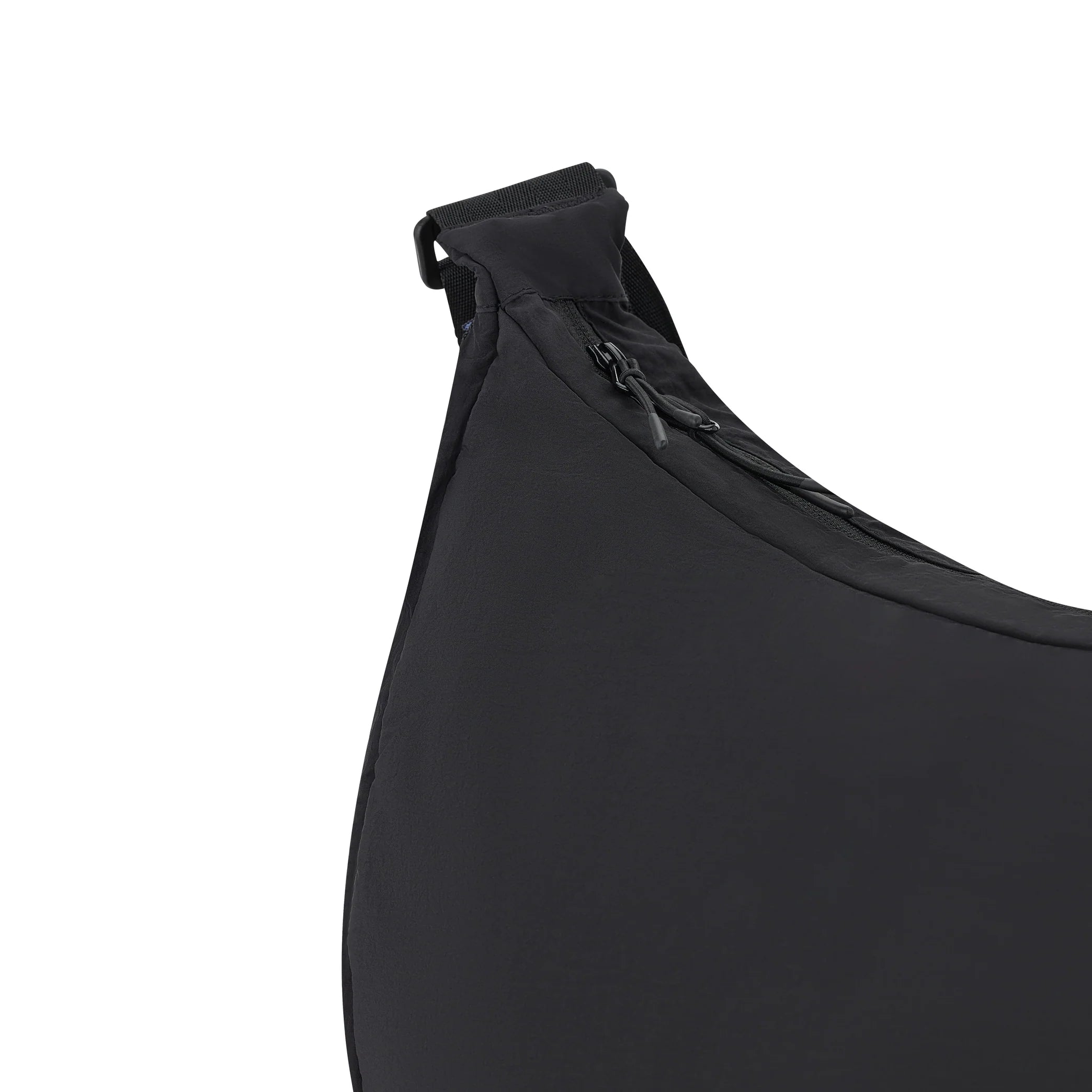 Nahaufnahme einer schwarzen Stofftasche, die in der oberen Ecke mit einem Reißverschluss und einem kleinen Kunststoffriemen versehen ist. Das Material erscheint glatt und leicht strukturiert.