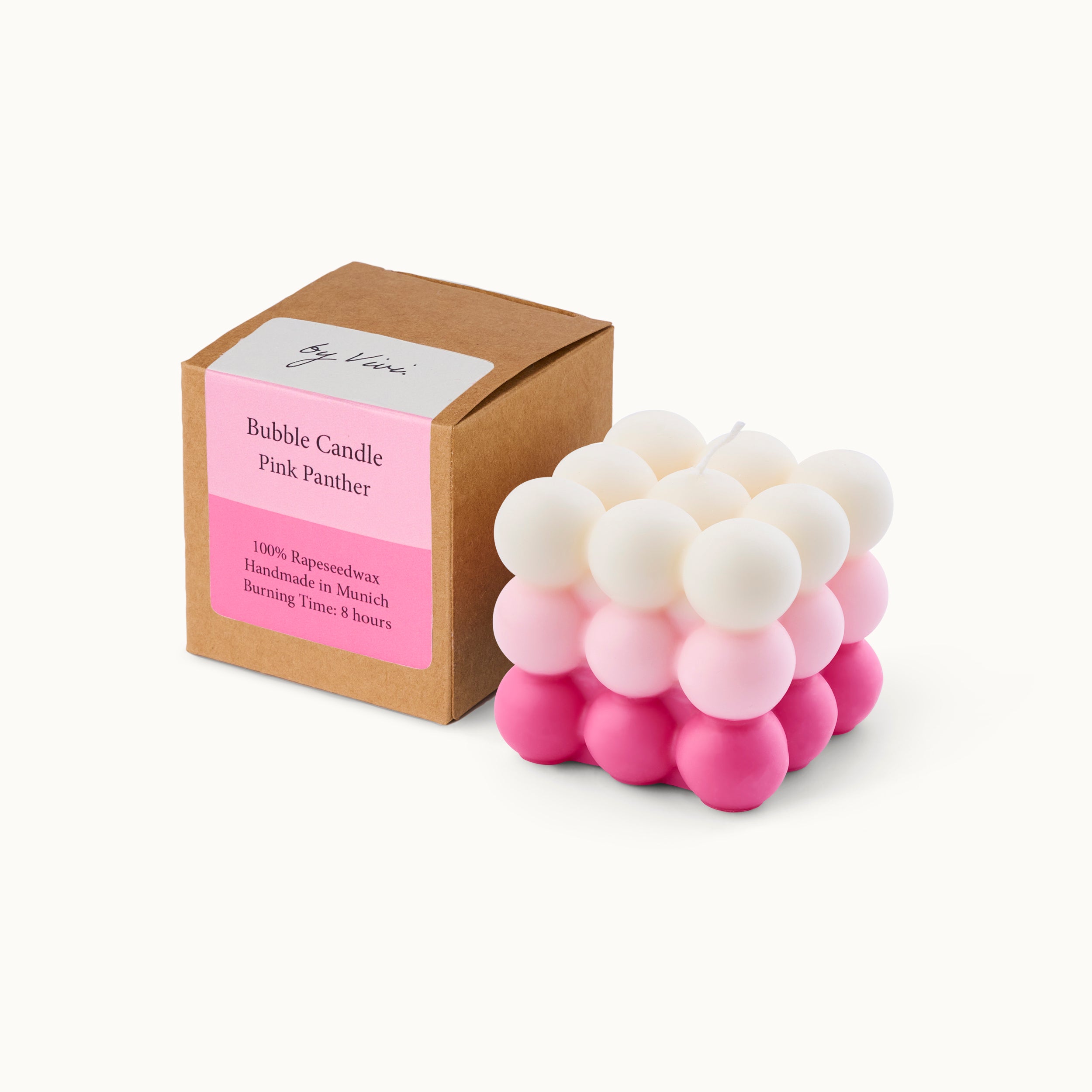 Kartonverpackung und rosa-weiße Bubble-Kerze in Kubusform auf weißem Hintergrund.