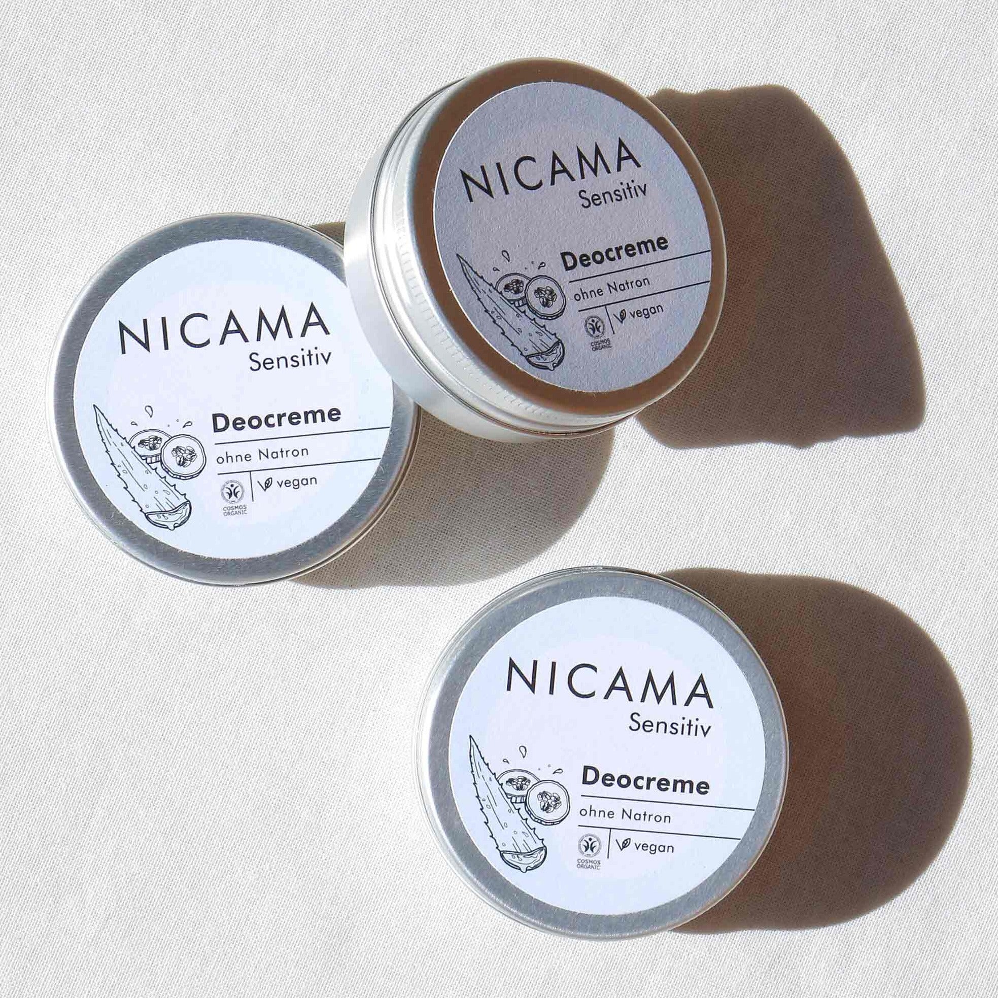 Drei Dosen NICAMA Sensitive Deocreme, vegan und ohne Natron, auf hellem Untergrund.