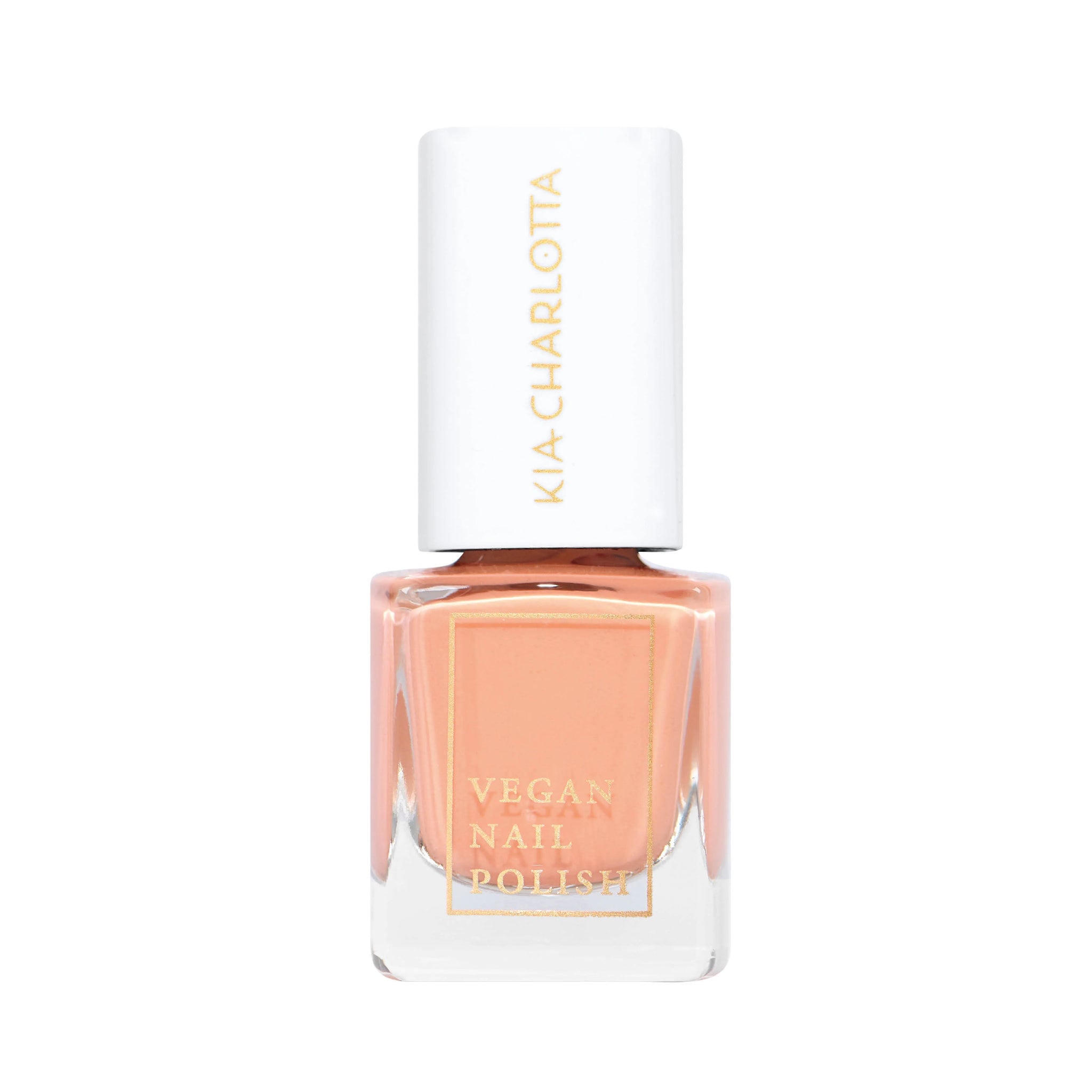 Eine Flasche veganer Nagellack in Pfirsichfarbe mit weißem Verschluss und goldenem Schriftzug.