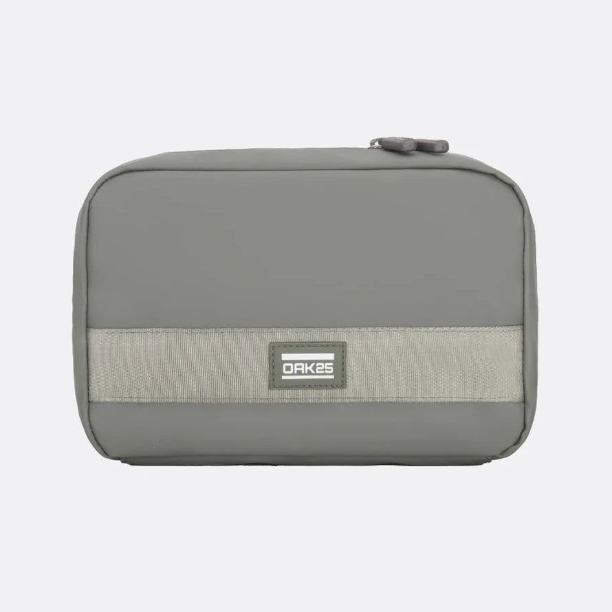 Eine rechteckige, graue Reißverschlusstasche mit einem hellgrauen horizontalen Band und einem kleinen "OAKES"-Etikett auf der Vorderseite vor einem schlichten hellen Hintergrund.