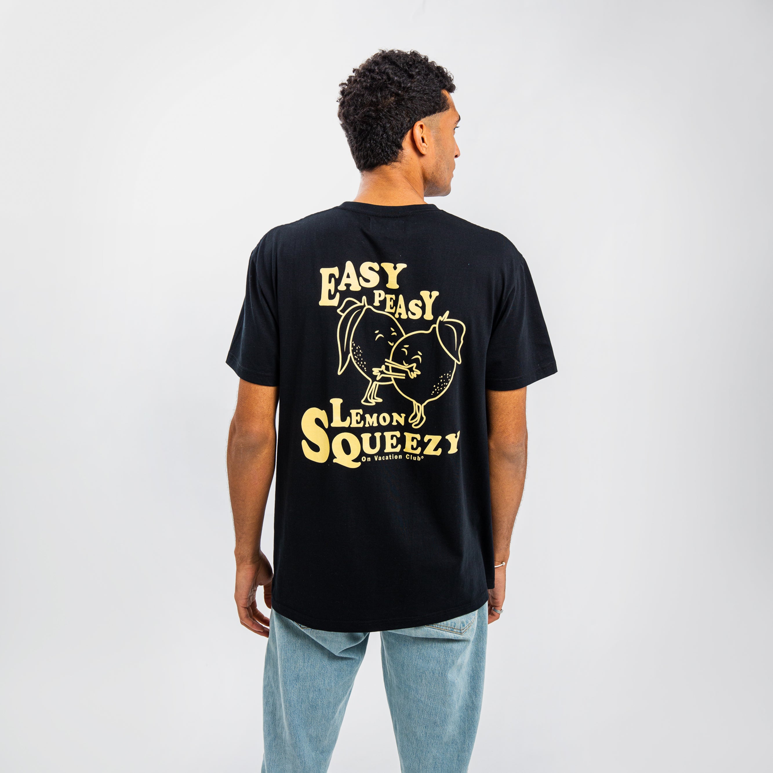 Ein Mann trägt ein schwarzes T-Shirt mit gelbem Aufdruck "Easy Peasy Lemon Squeezy" und einer gedehnten Zitrone.