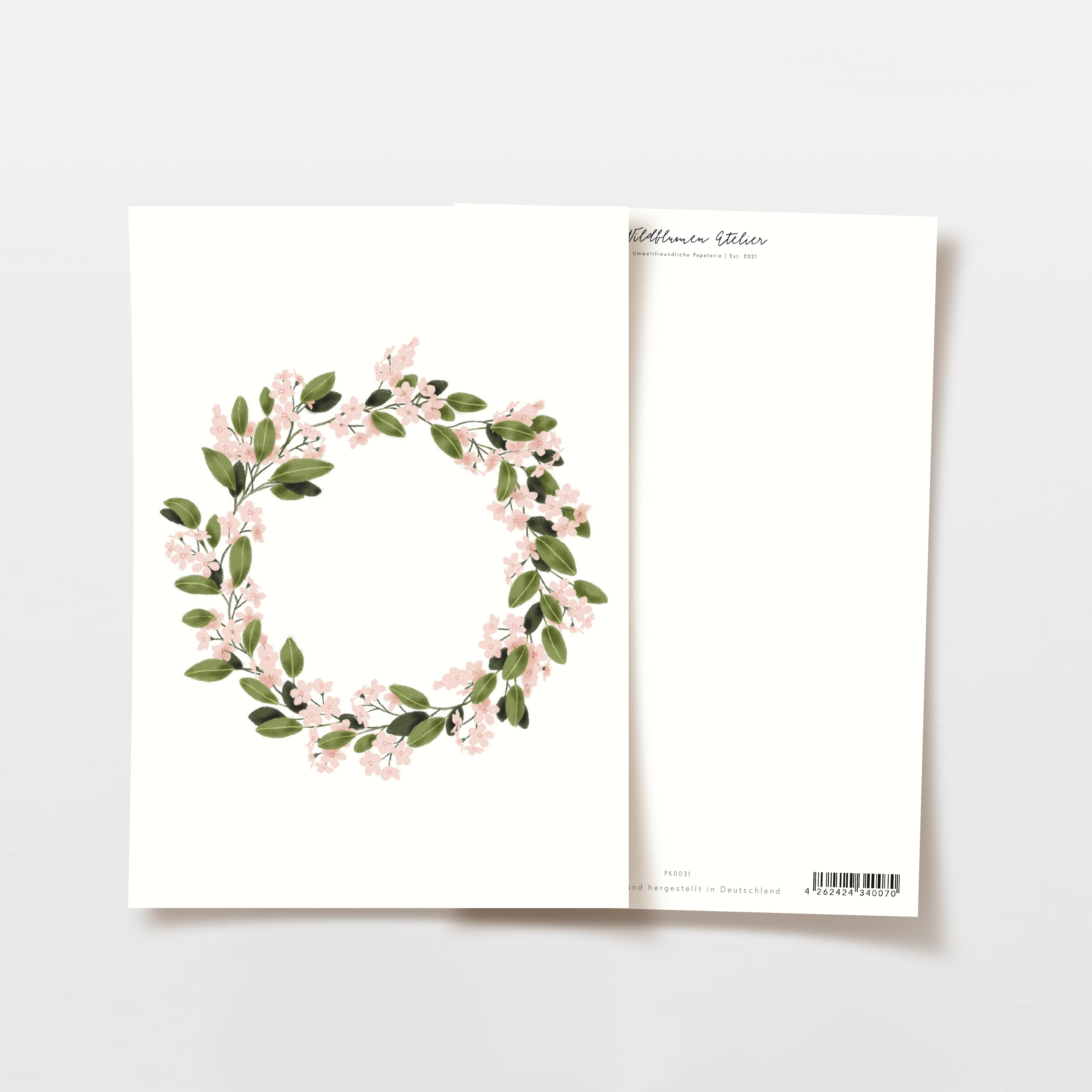 Zwei Karten mit Blumenkranz-Design, auf der Vorderseite zartrosa Blüten und grüne Blätter, Rückseite schlicht.